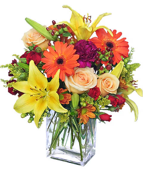Mixed bouquet of lilies, roses, and gerbera daisies in a clear glass vase