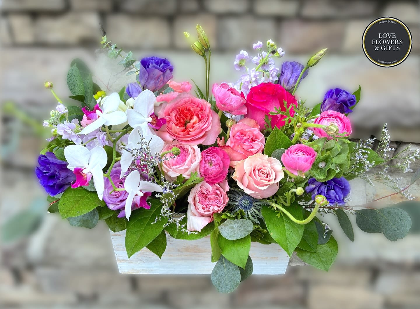 Valley of the Orchid  - Elegant textures and colors of lavenders and pinks with orchids designed in a wide wooden box. 
