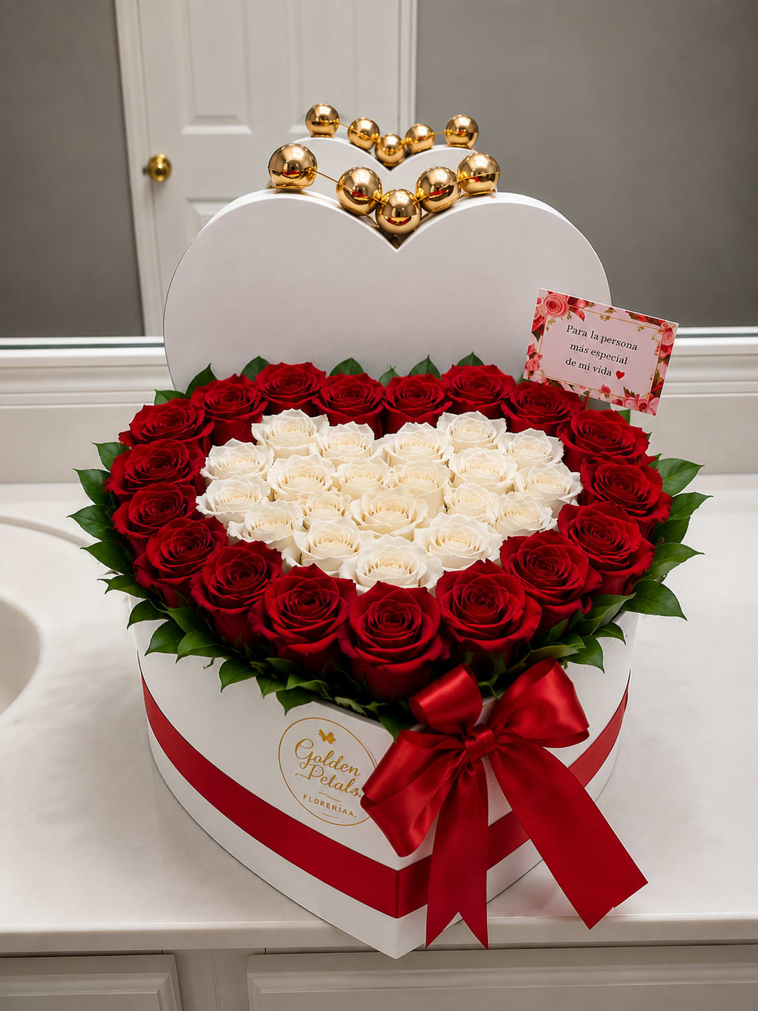 Heart-shaped box of red and white roses with a red ribbon