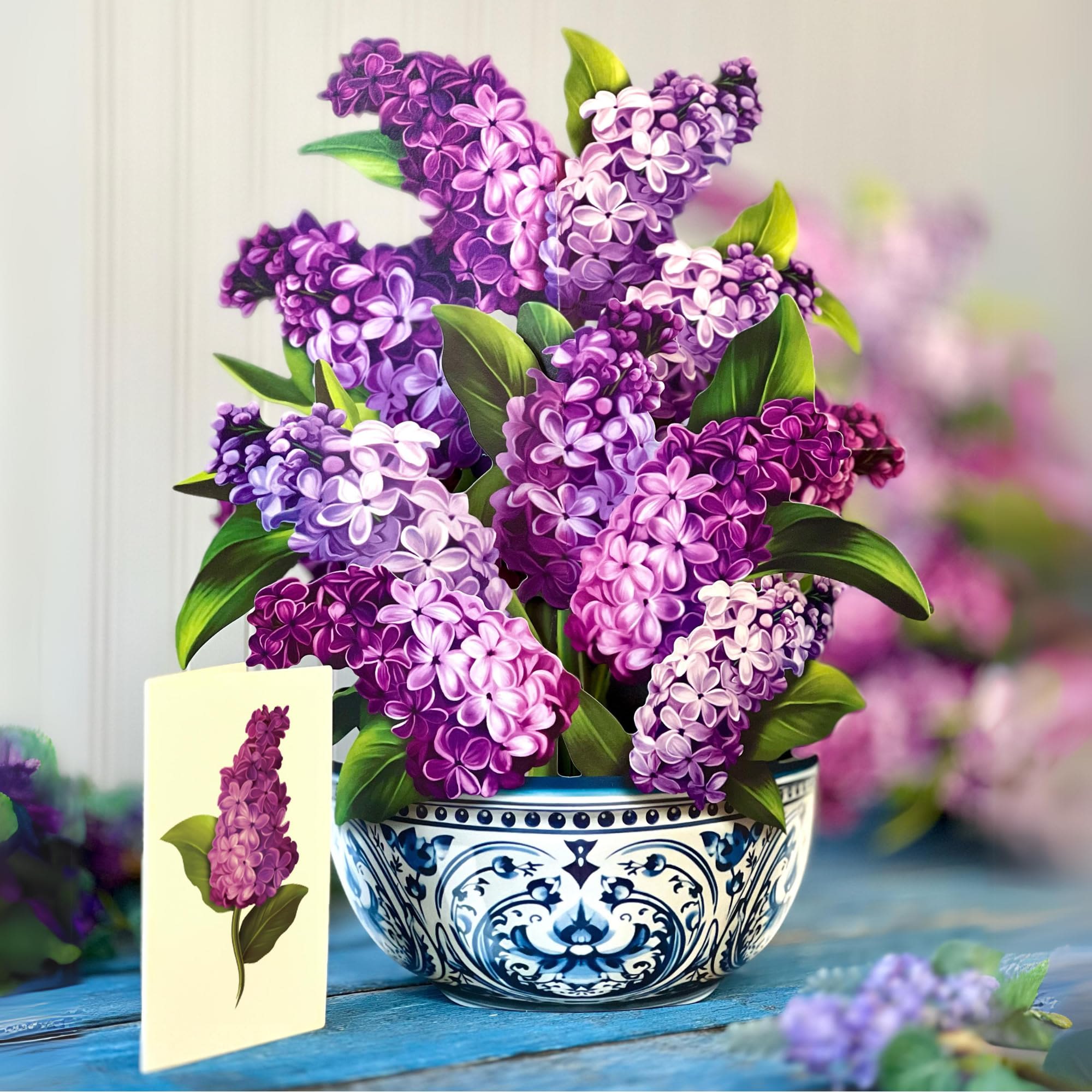 Purple lilac bouquet in a blue-and-white ceramic bowl