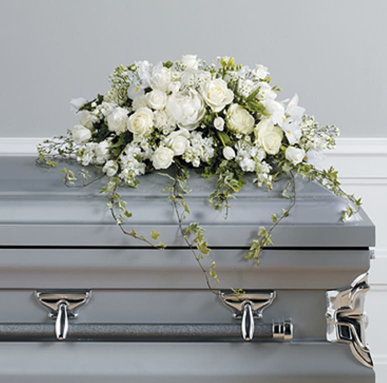 White floral spray on a silver casket