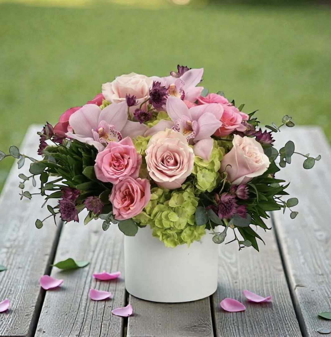 Whispering Petals - Whispering Petals – Elegant Pink &amp; Green Flower Arrangement in Wilmington, Delaware  Soft, romantic, and effortlessly elegant, this lush arrangement features a delicate blend of green hydrangea, pale pink roses, pink cymbidium orchids, and other premium blush-toned blooms, artfully arranged in a modern white cylinder vase. Designed with a gentle, airy feel, Whispering Petals is perfect for celebrating life’s meaningful moments—whether you’re sending a birthday surprise, anniversary flowers, sympathy tribute, or simply a thoughtful “thinking of you” gift. The soft pink palette paired with fresh green hydrangea creates a timeless look that complements any home or office décor. If you’re searching for flower delivery in Wilmington, DE, this arrangement offers a sophisticated and feminine option that stands out for its beauty and freshness. Product Details: Style: All-around arrangement in a white cylinder vase Flowers: Green hydrangea, pale pink roses, pink cymbidium orchids, and seasonal pale pink blooms Color Palette: Soft pinks and fresh greens Occasion: Birthday, anniversary, sympathy, get well, or everyday elegance Local Wilmington, Delaware Florist Advantage  Each Whispering Petals arrangement is hand-designed with the freshest flowers available by your trusted Wilmington DE florist. We proudly provide same-day flower delivery in Wilmington, Delaware and nearby areas, ensuring your gift arrives beautifully presented and on time.