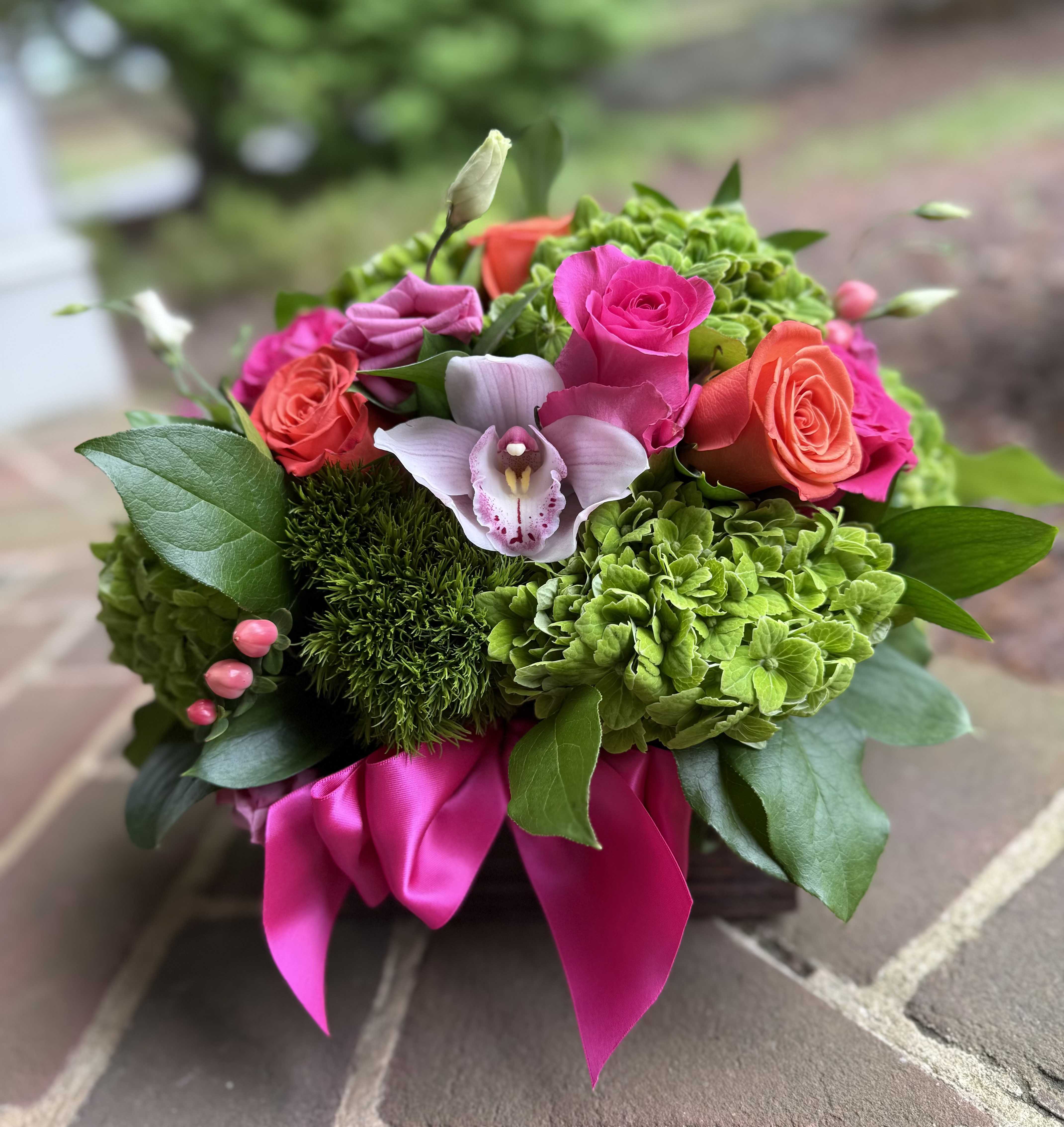 Sunset Citrus - Sunset Citrus - Wilmington DE, Local Delivery  Lush greens, vibrant pinks, electric oranges, "Sunset Citrus" is the way to say you have mom on your mind this Mother's Day. Featuring hydrangea, roses, and an orchid, this arrangement will put a smile on your mom's face!   Perfect for birthdays, congratulations, get well wishes or just because, this cheerful bouquet adds a pop of color and a touch of luxury. Handcrafted by your trusted Wilmington florist, each arrangement is made fresh to order using premium seasonal flowers.  Why Choose Us? Hand-delivered by a Wilmington Florist Fast, reliable flower delivery in Wilmington, DE High-end blooms, expertly arranged with care.  Order now and brighten someone's day with Sunset Citrus - a standout floral gift from your go-to Wilmington, Delaware flower shop. 
