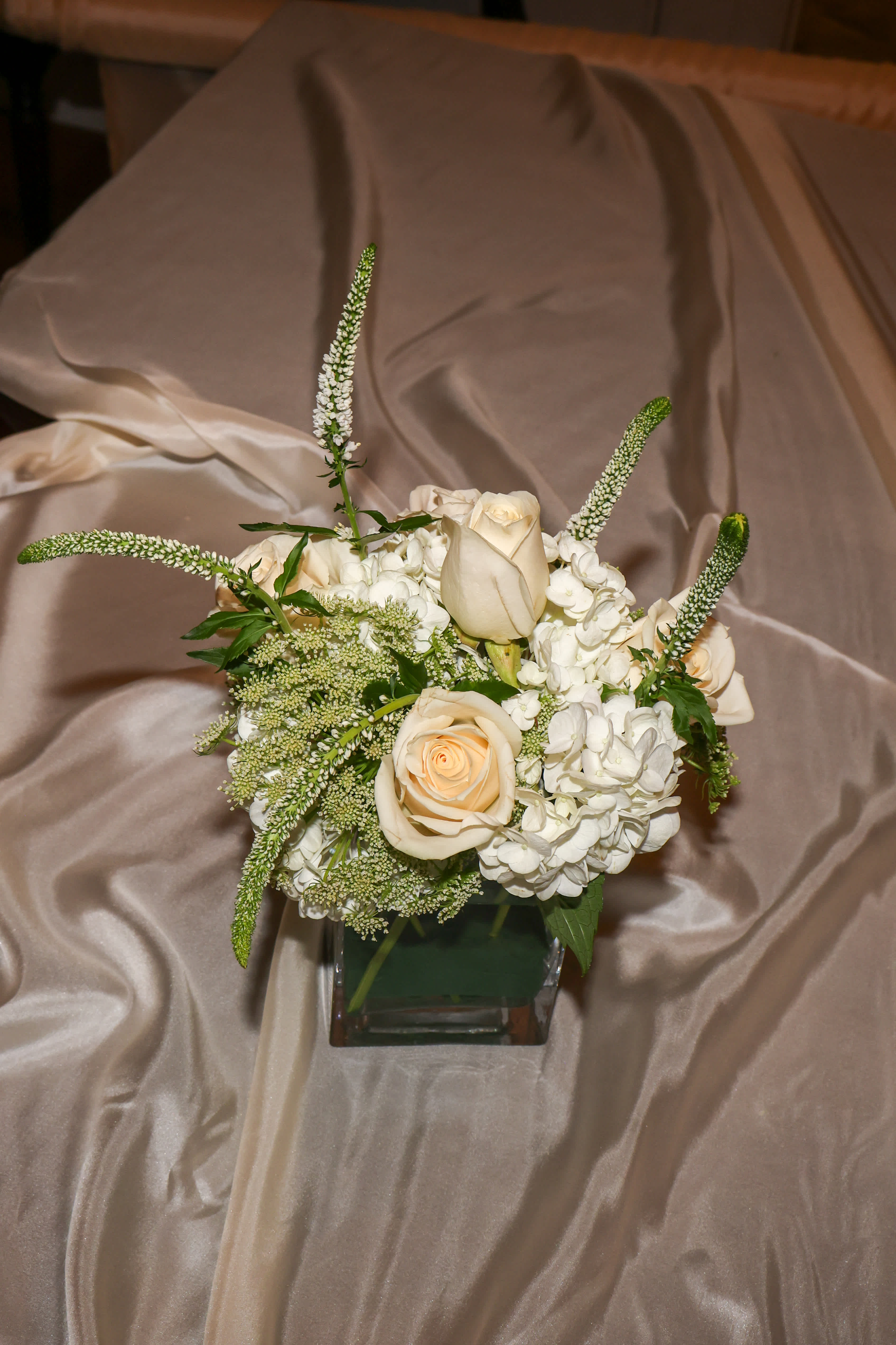 Cream roses and white hydrangeas in a square glass vase