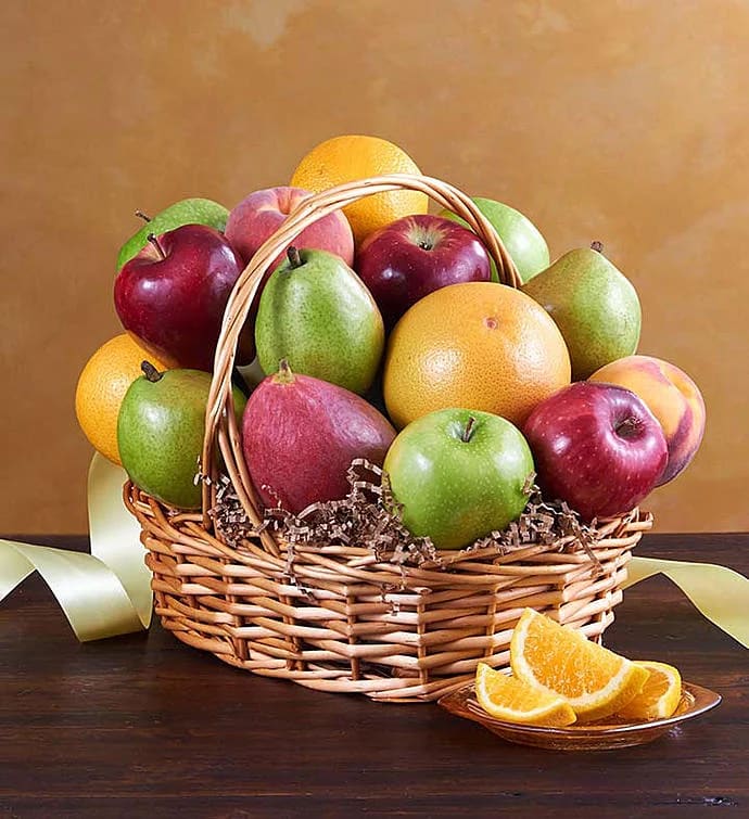 Basket of assorted fruit with orange slices on a plate