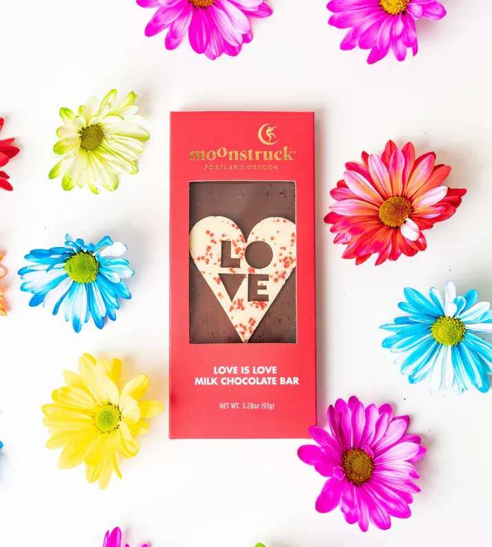 Red boxed chocolate bar with heart-shaped LOVE design surrounded by colorful daisies.