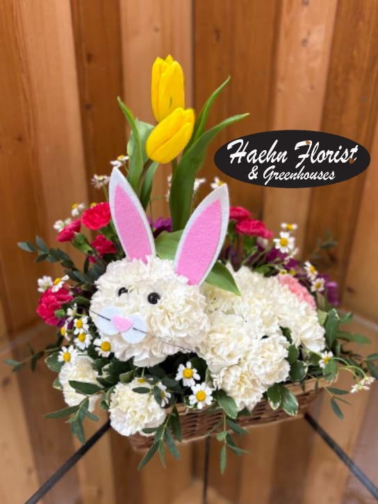 Basket arrangement with a bunny face, pink ears, and yellow tulips