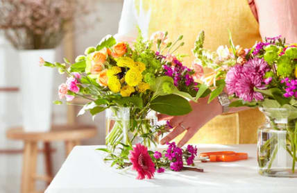 Two colorful flower bouquets in glass vases on a table