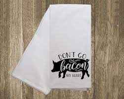White kitchen towel with a black pig graphic and text