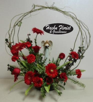 Angel in Red - Fresh cut red flowers circling an angel.  *Keepsake gifts will be very similar as our suppliers change their inventory with trends. Haehn Florist &amp; Greenhouses in Wapakoneta, OH