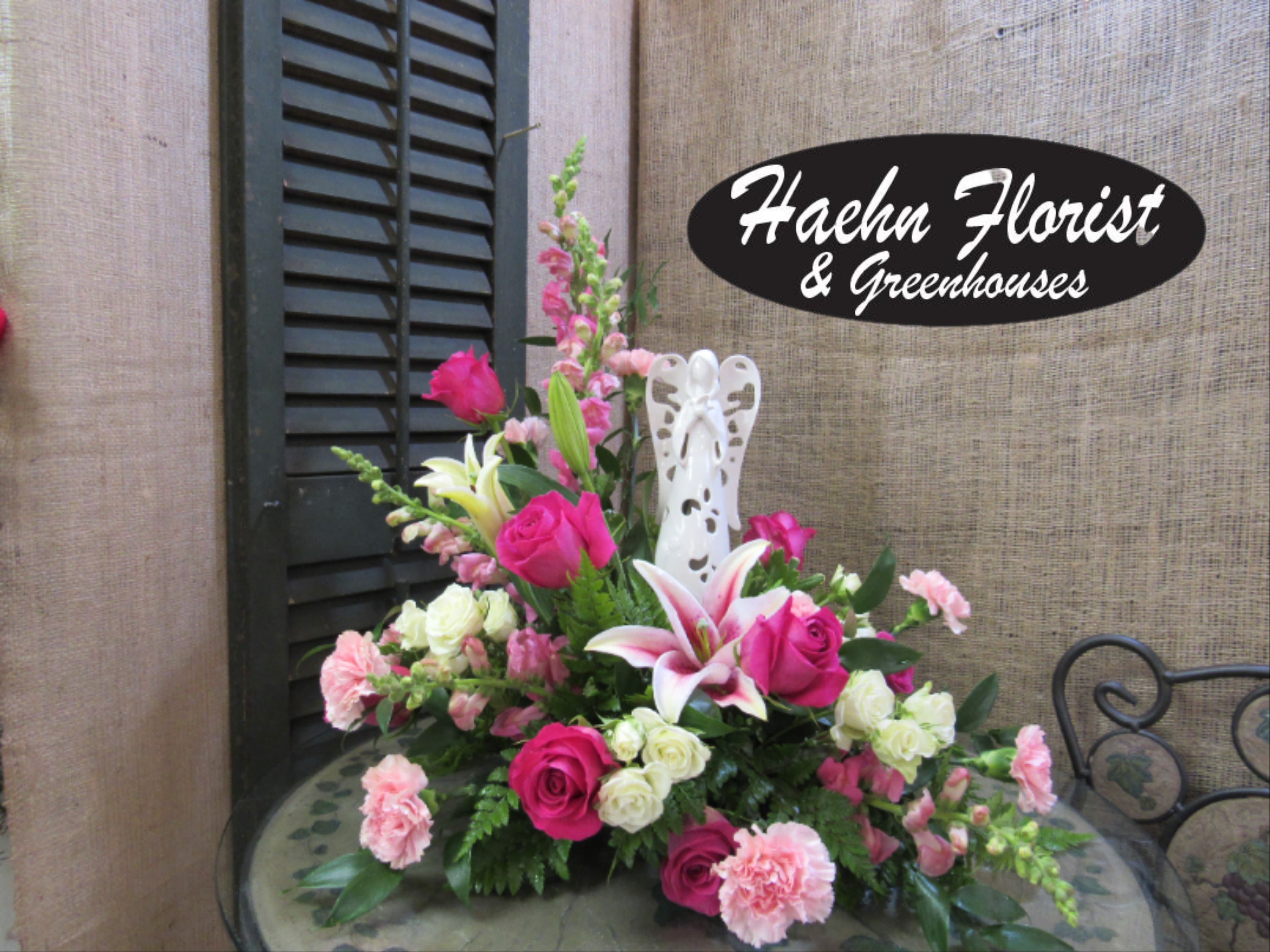 Pink and white floral arrangement with roses, lilies, and carnations