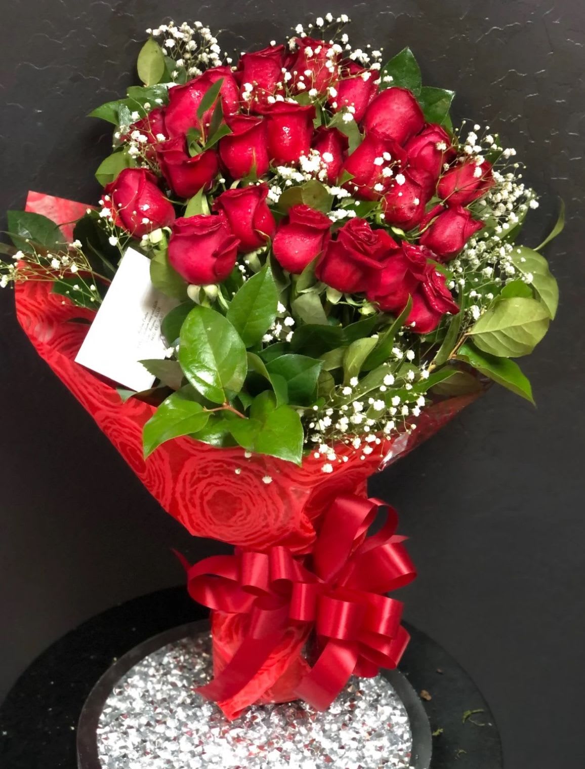 Bouquet of red roses with baby's breath and a red ribbon wrap
