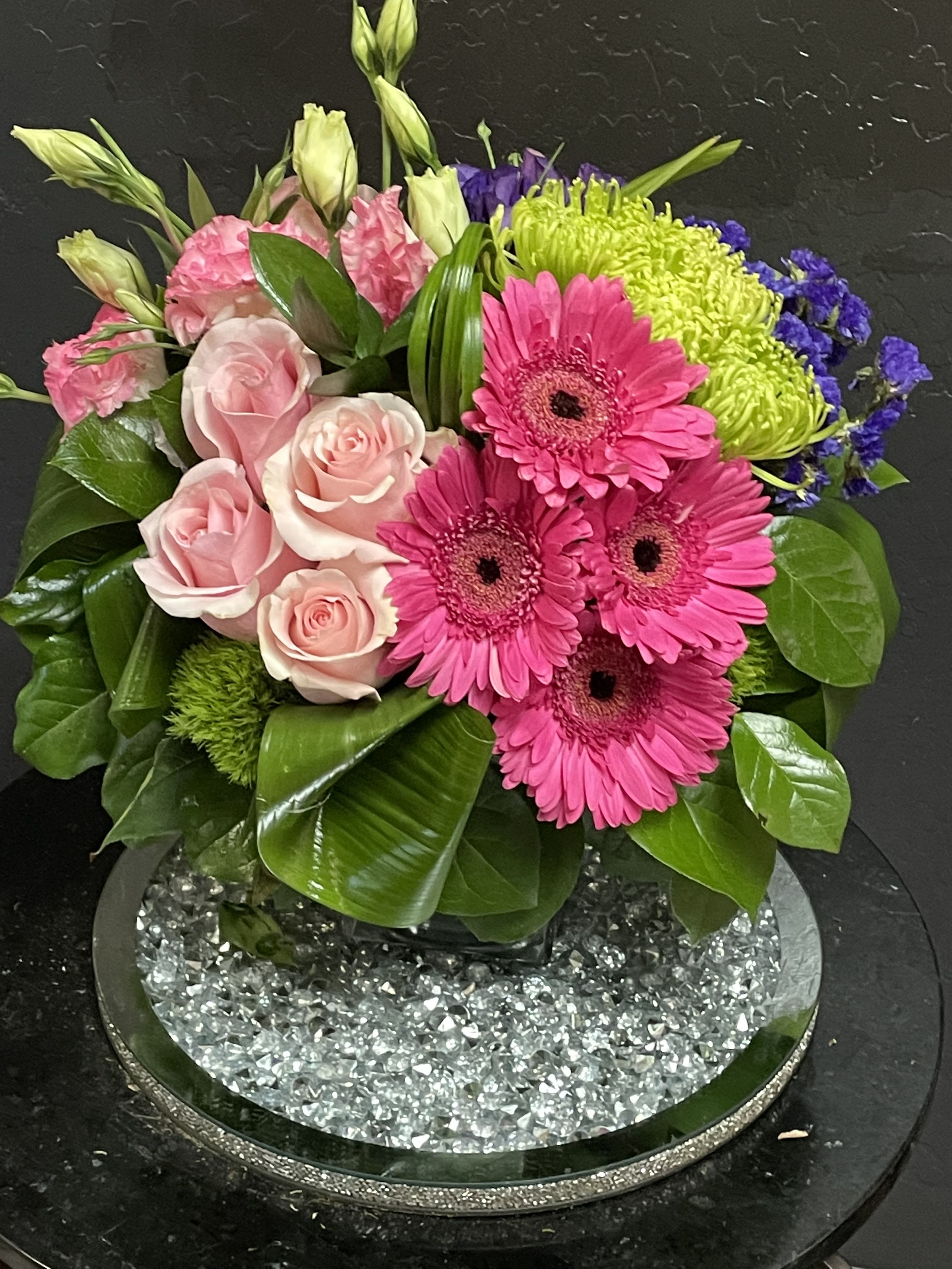 Pink roses and gerbera daisies in a low glass vase