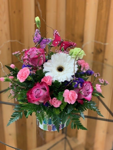 Pink roses and carnations with a white gerbera daisy in a patterned vase