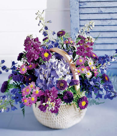 Basket of purple and blue mixed flowers with a handle