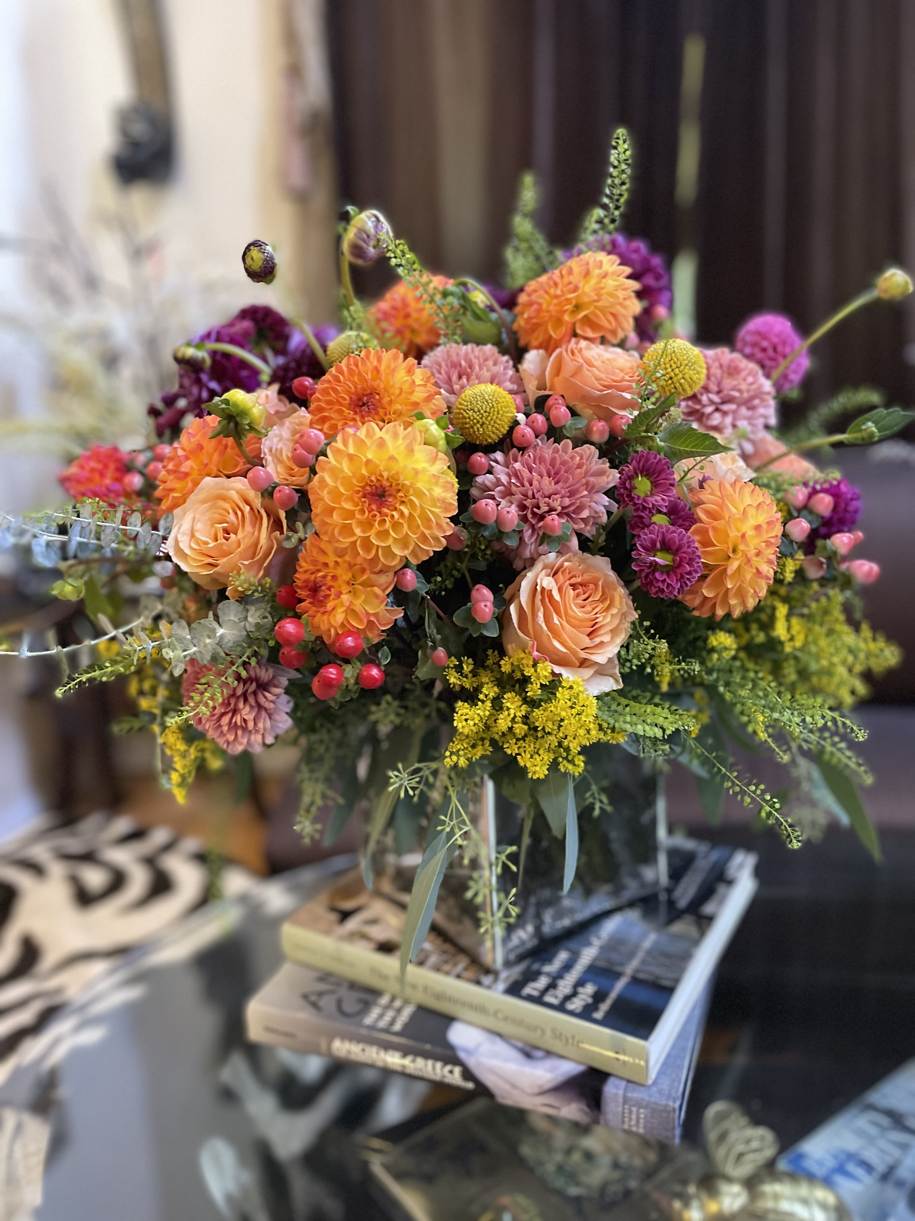 Colorful bouquet of orange, pink, and purple flowers in a glass vase