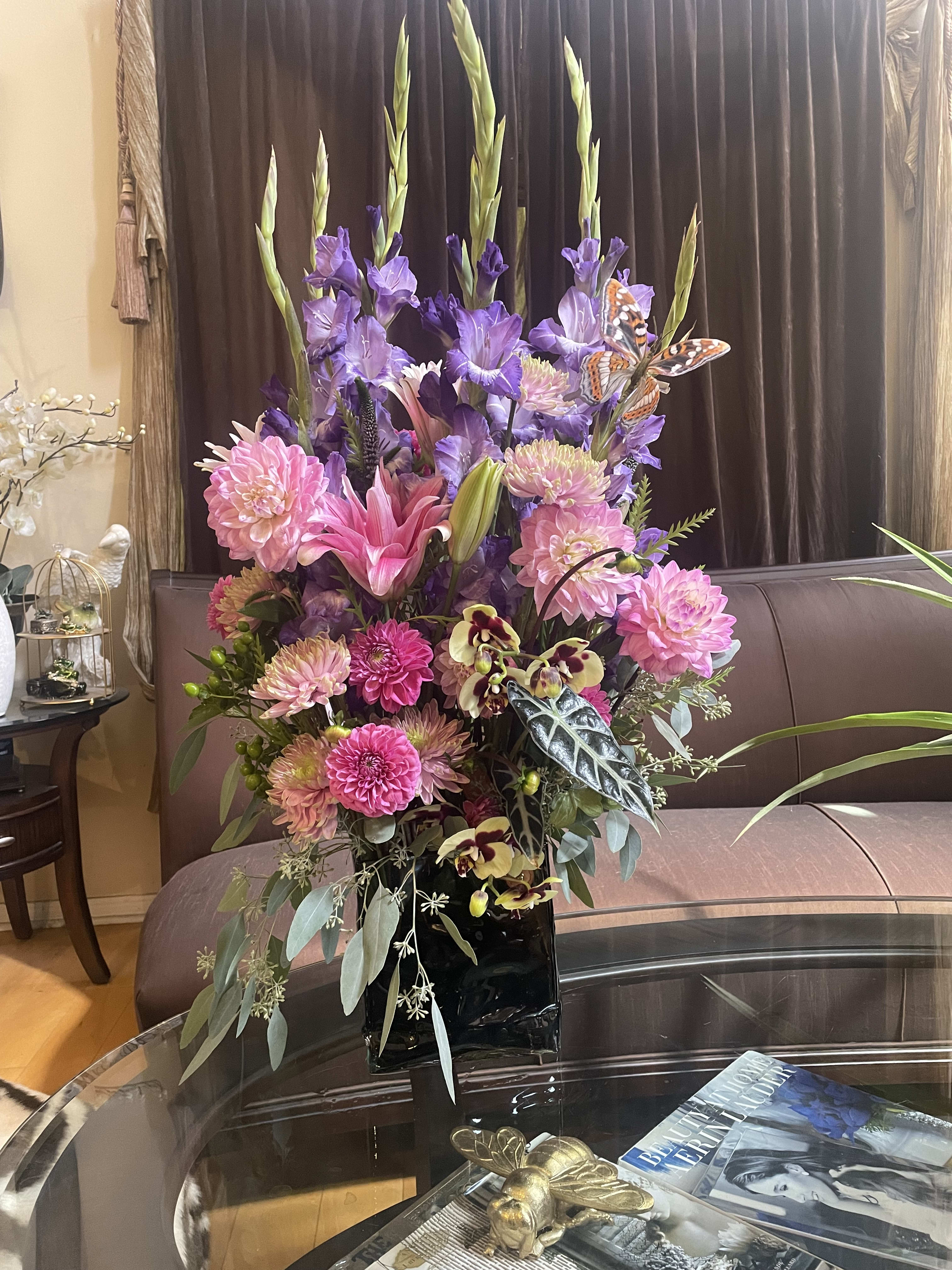 Tall bouquet of pink and purple flowers in a black vase