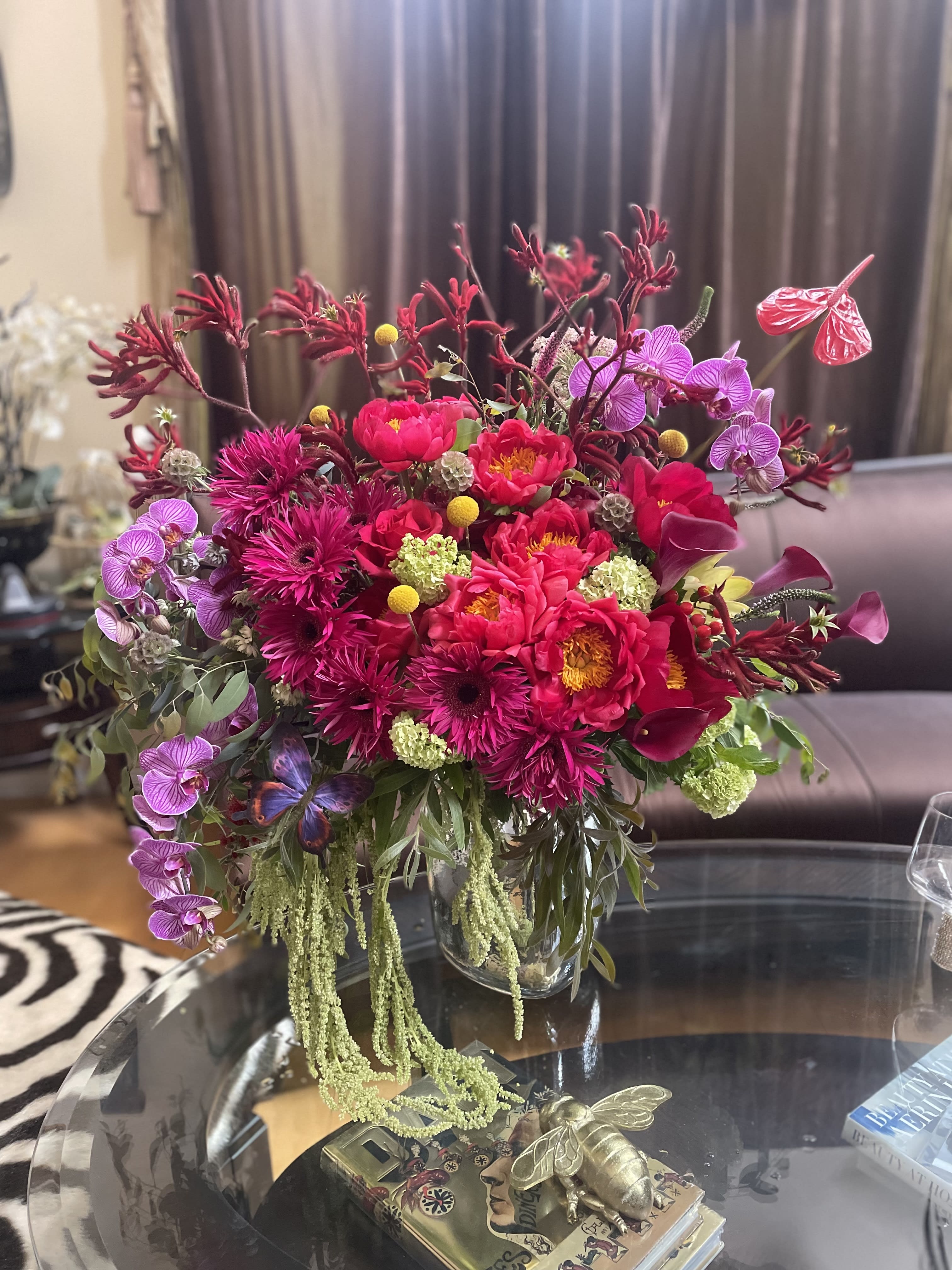 Bright pink floral arrangement in a clear glass vase with orchids and calla lilies