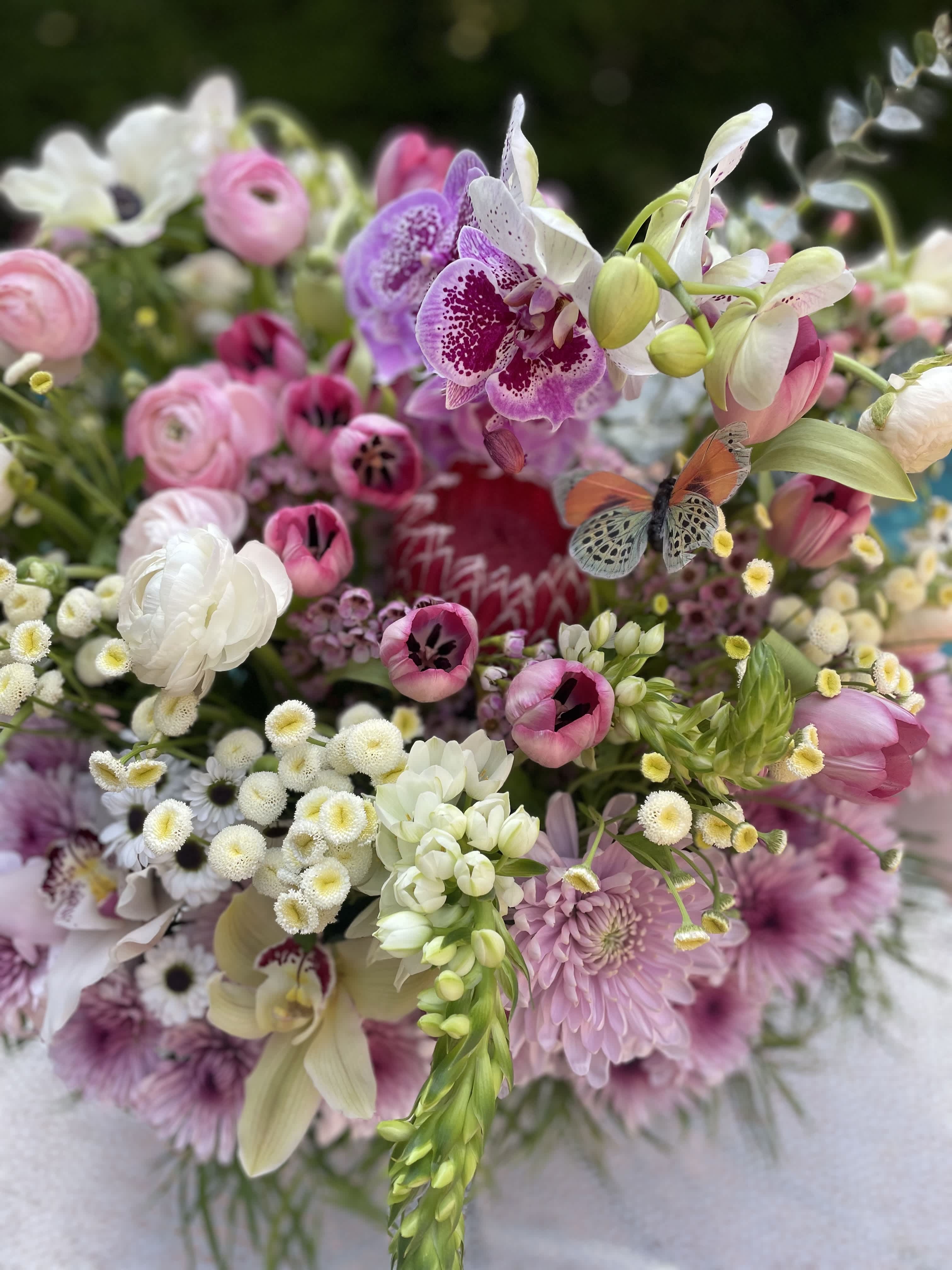 Mixed bouquet of pink, white, and purple flowers with orchids and tulips