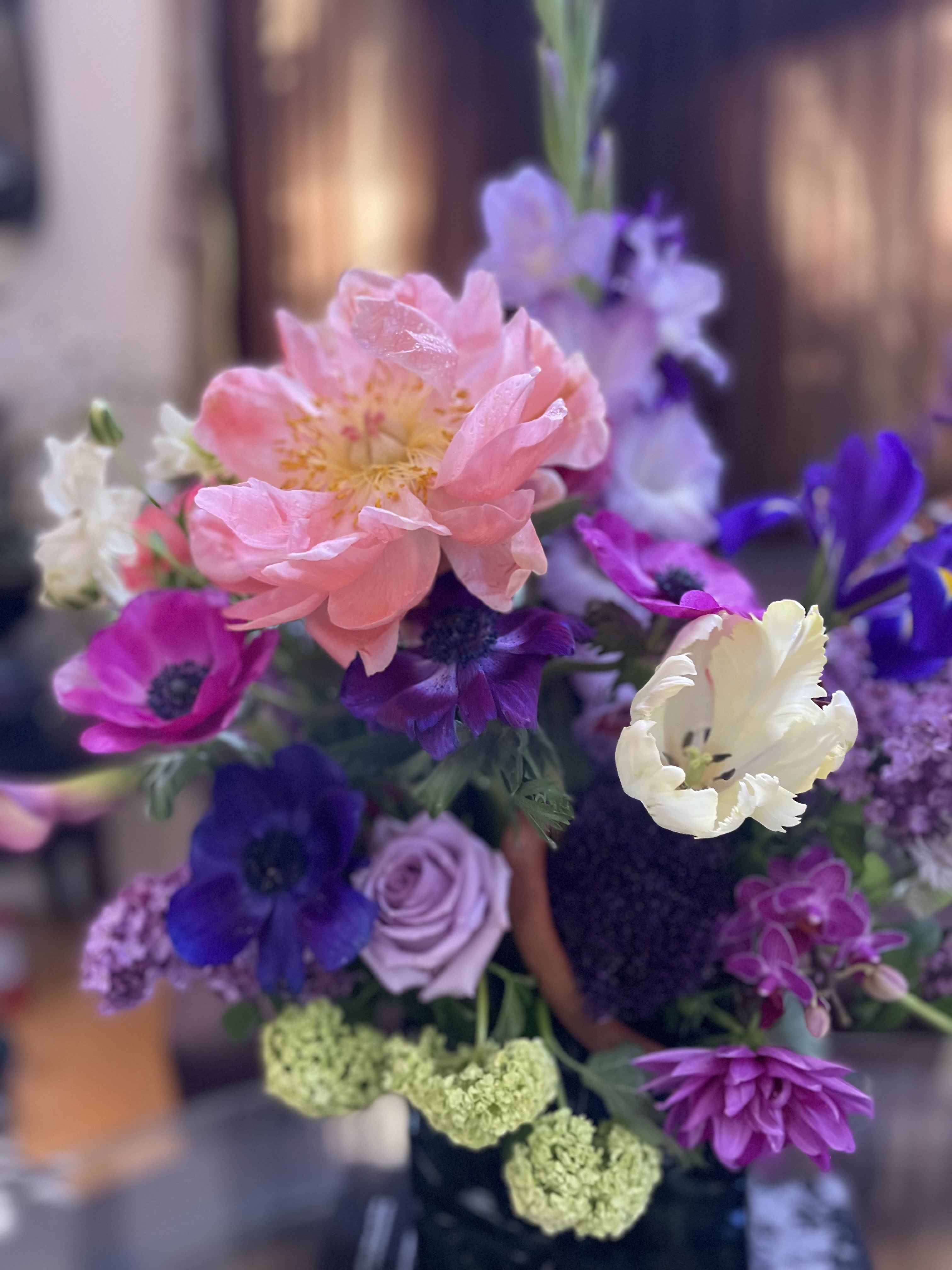 Bouquet of pink, purple, and white flowers with a large peach bloom