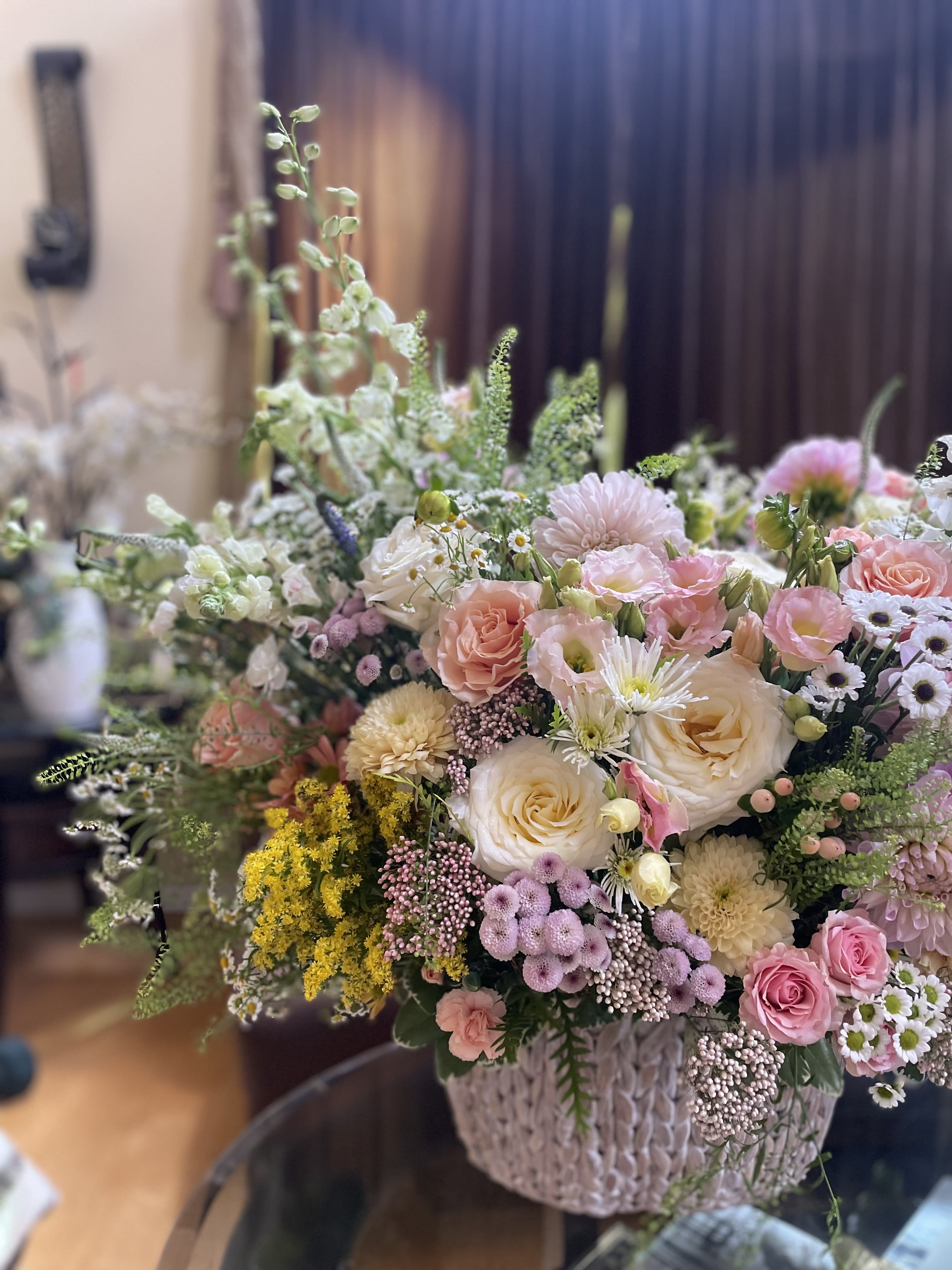 Large pastel flower arrangement in a woven basket