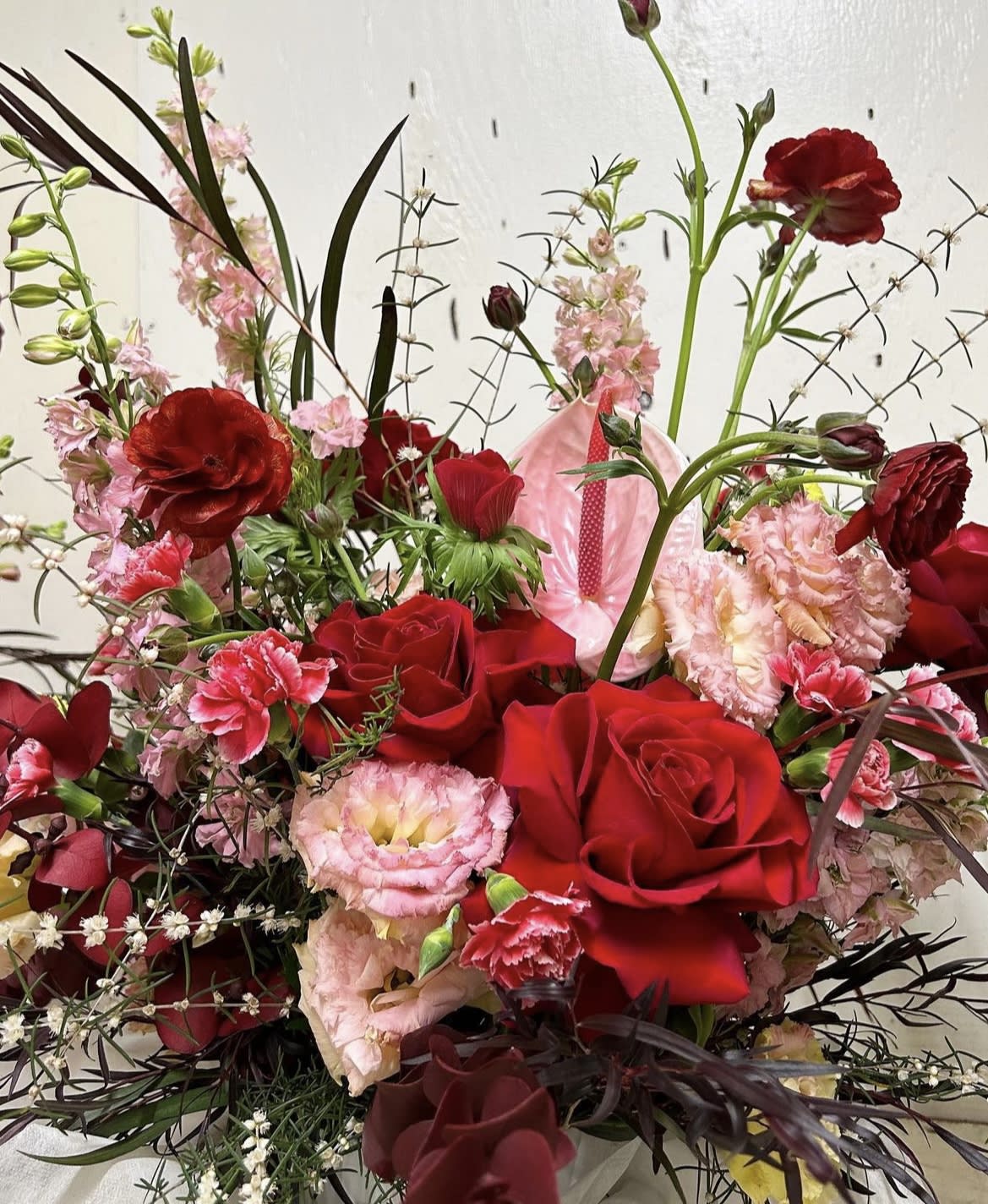 Red roses and pink carnations in a mixed bouquet with tall stems