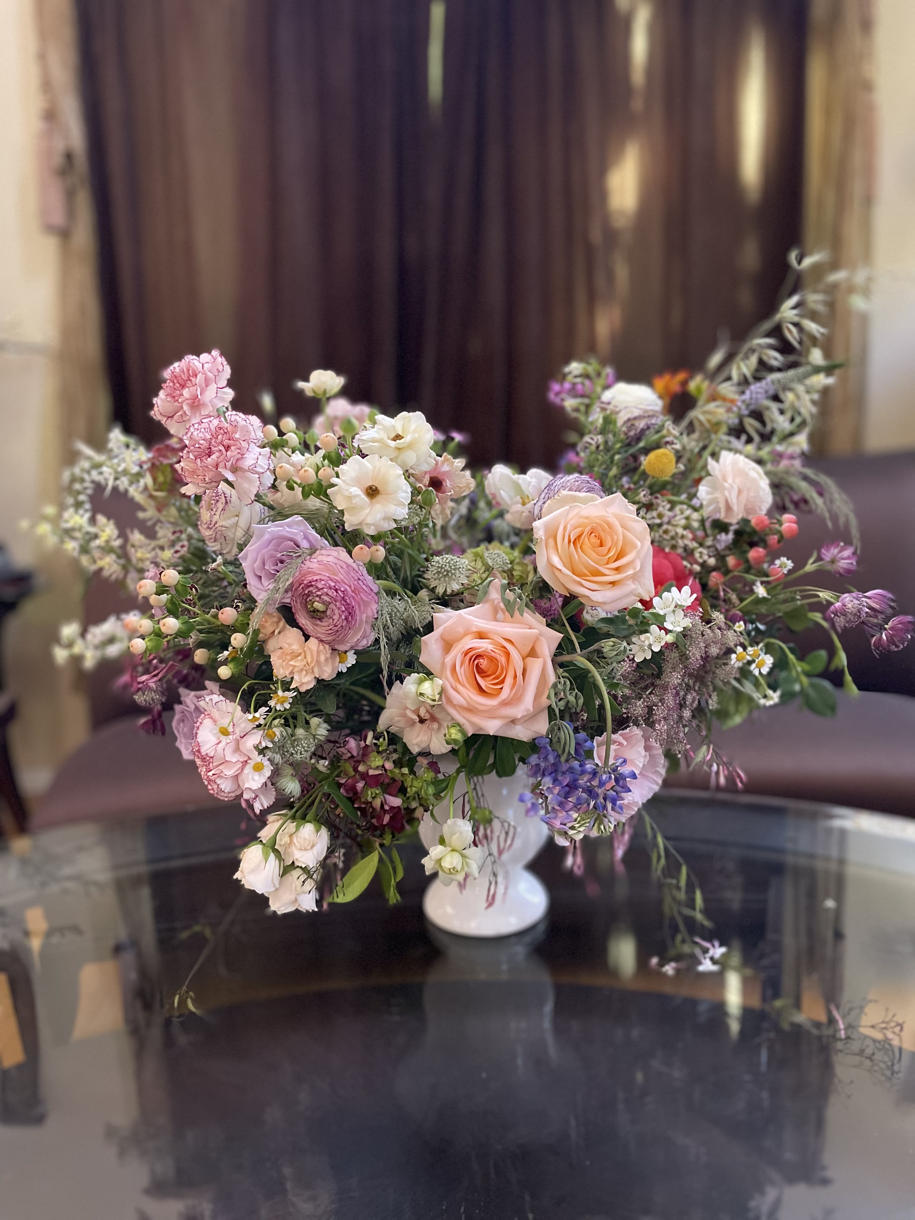 Mixed pastel bouquet in a white pedestal vase