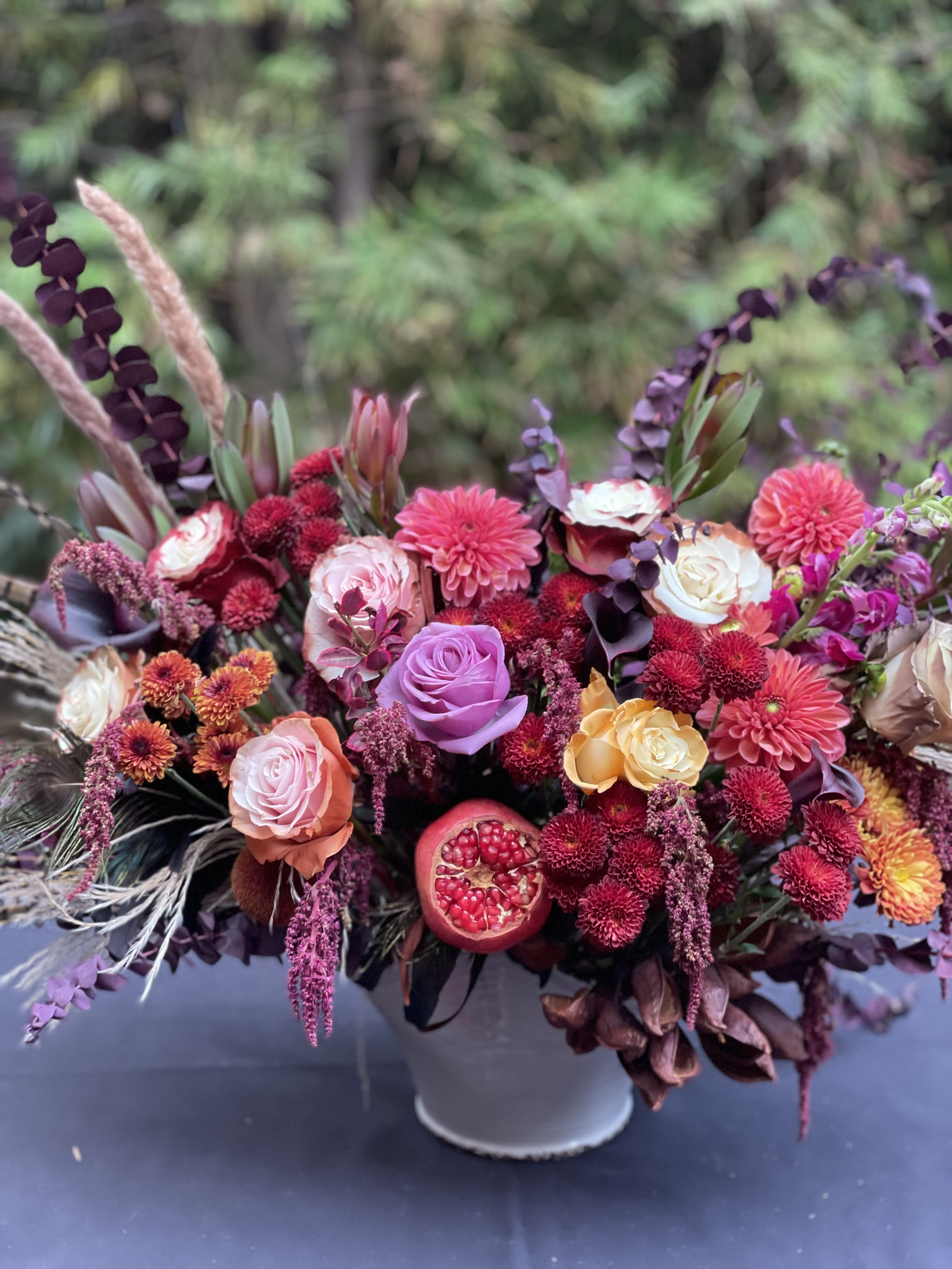 Mixed bouquet of pink, purple, and orange flowers in a white vase