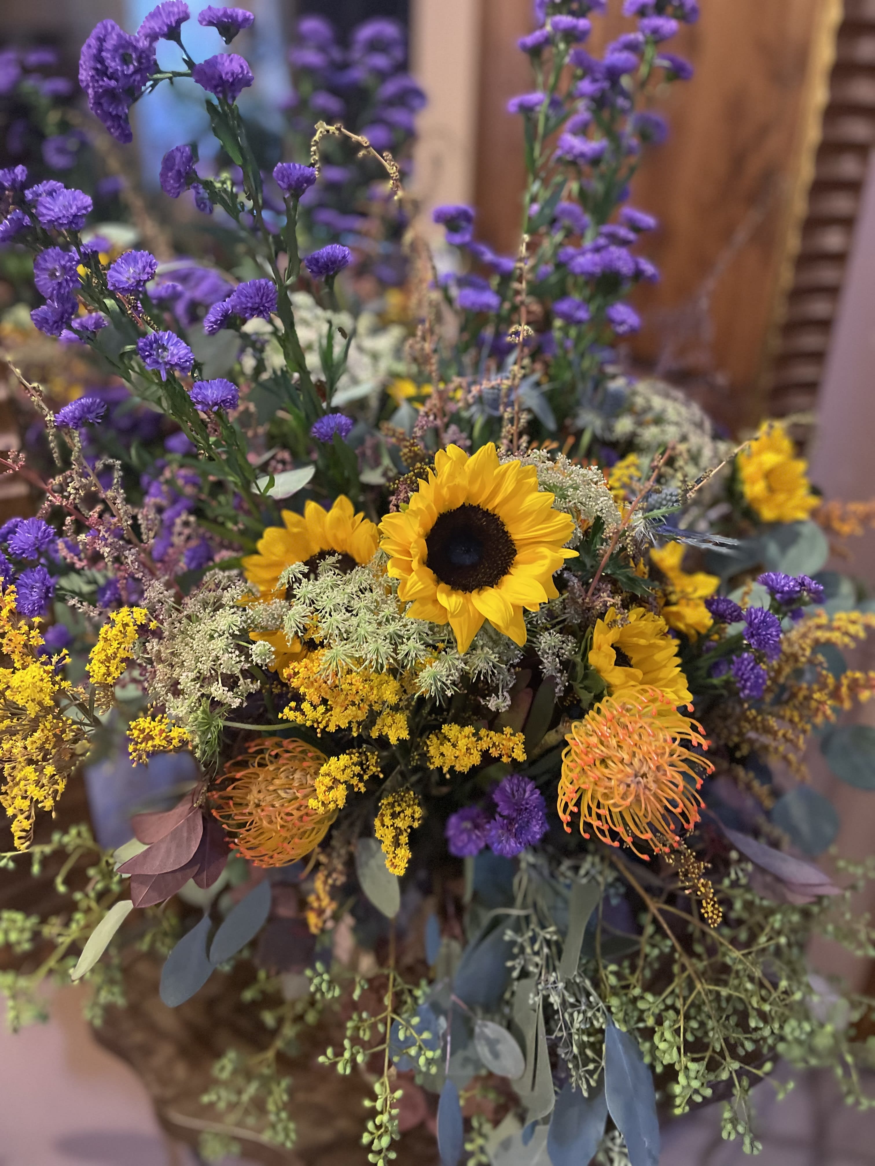 Bouquet with sunflowers, purple blooms, and yellow filler flowers