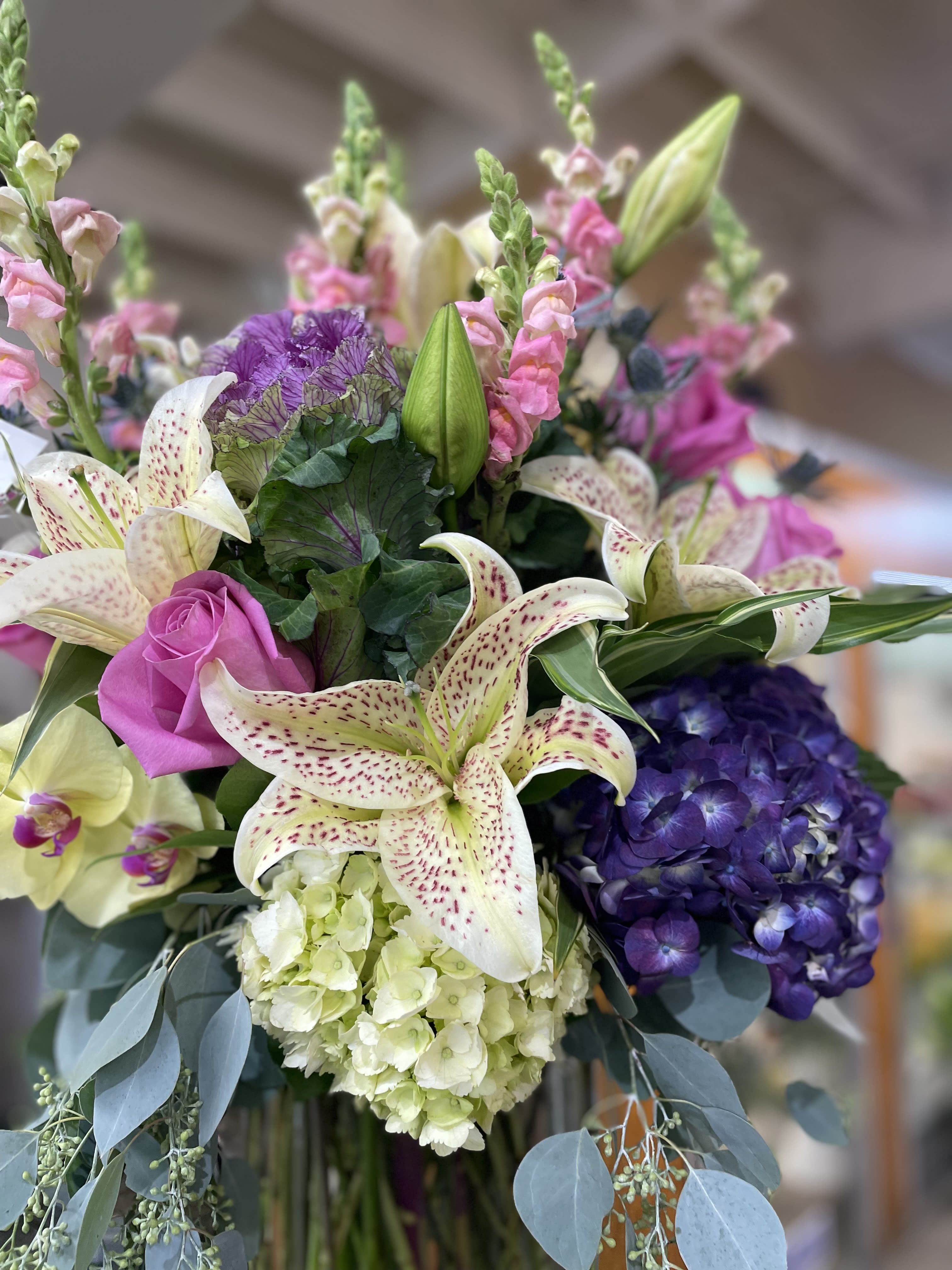 Bouquet of lilies, roses, hydrangea, and snapdragons in pink, purple, and white