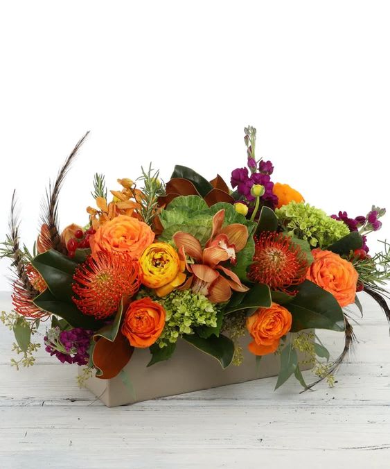 Orange and purple floral arrangement in a rectangular box