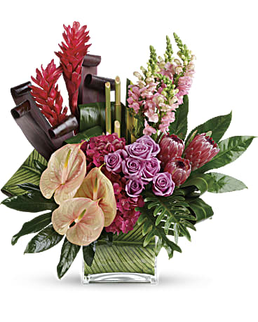 Tropical floral arrangement with pink roses and anthuriums in a glass vase