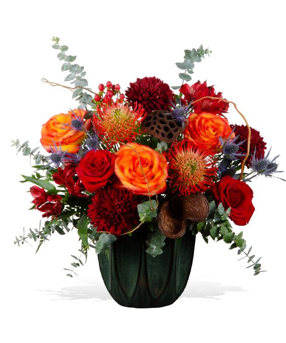 Red and orange floral arrangement in a dark vase