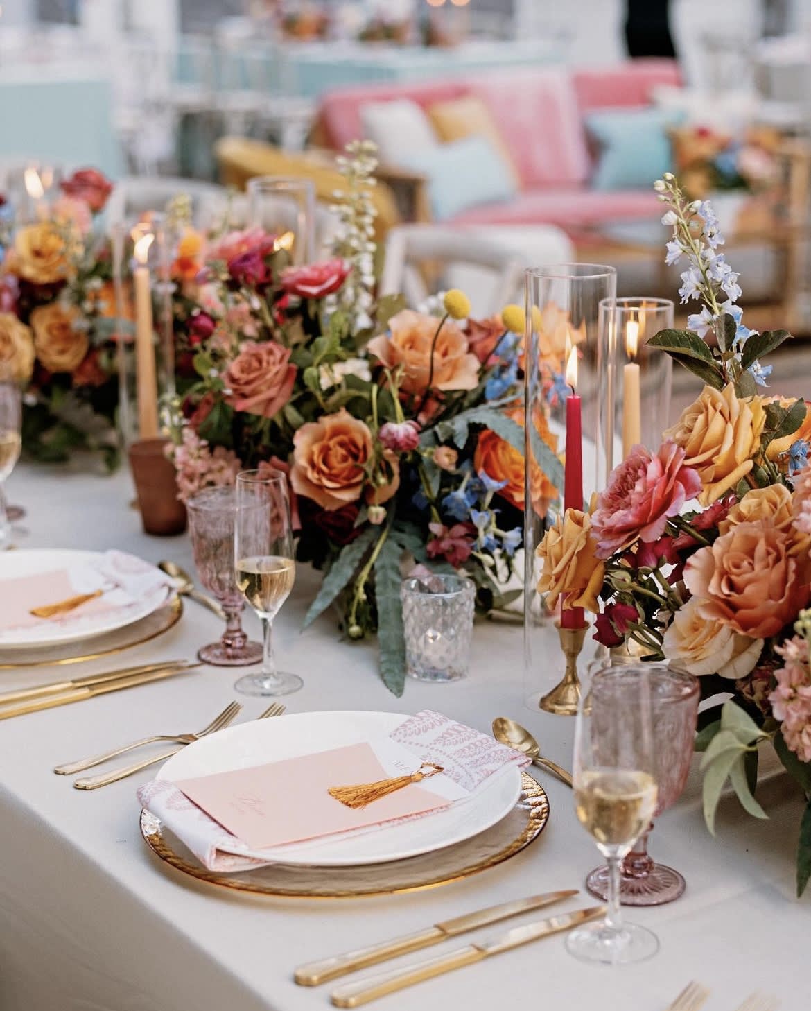 Floral table centerpieces with roses and candles on a set dining table