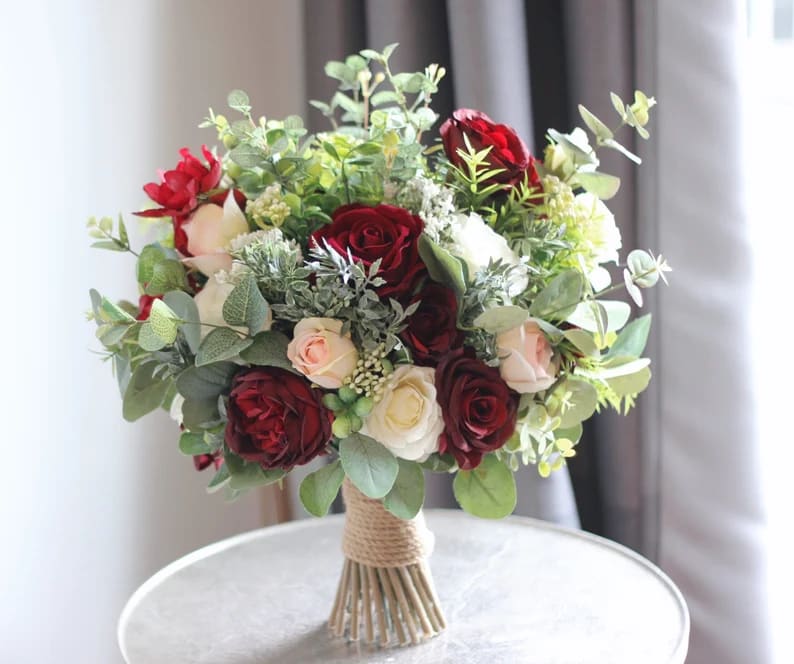 Bouquet of red, white, and blush roses with greenery