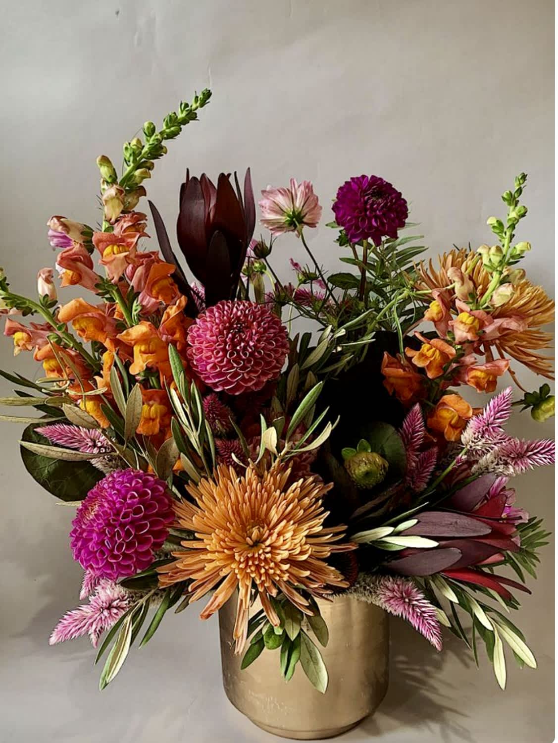 Colorful mixed flower arrangement in a gold vase