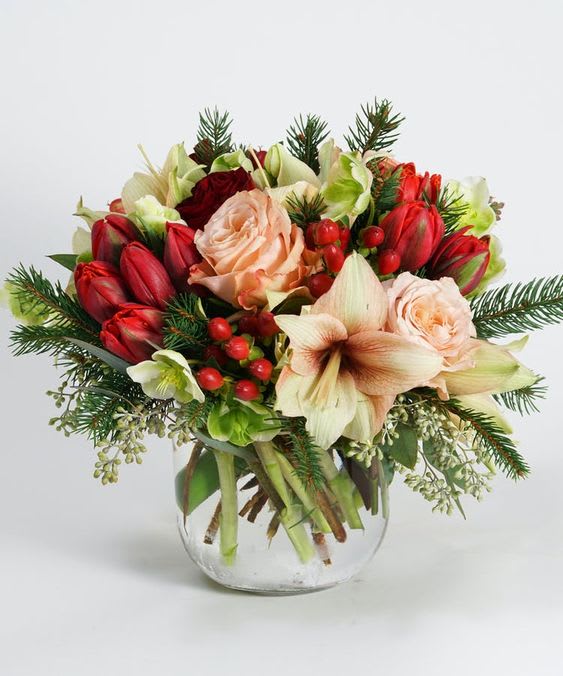 Bouquet of red and peach flowers in a clear glass vase