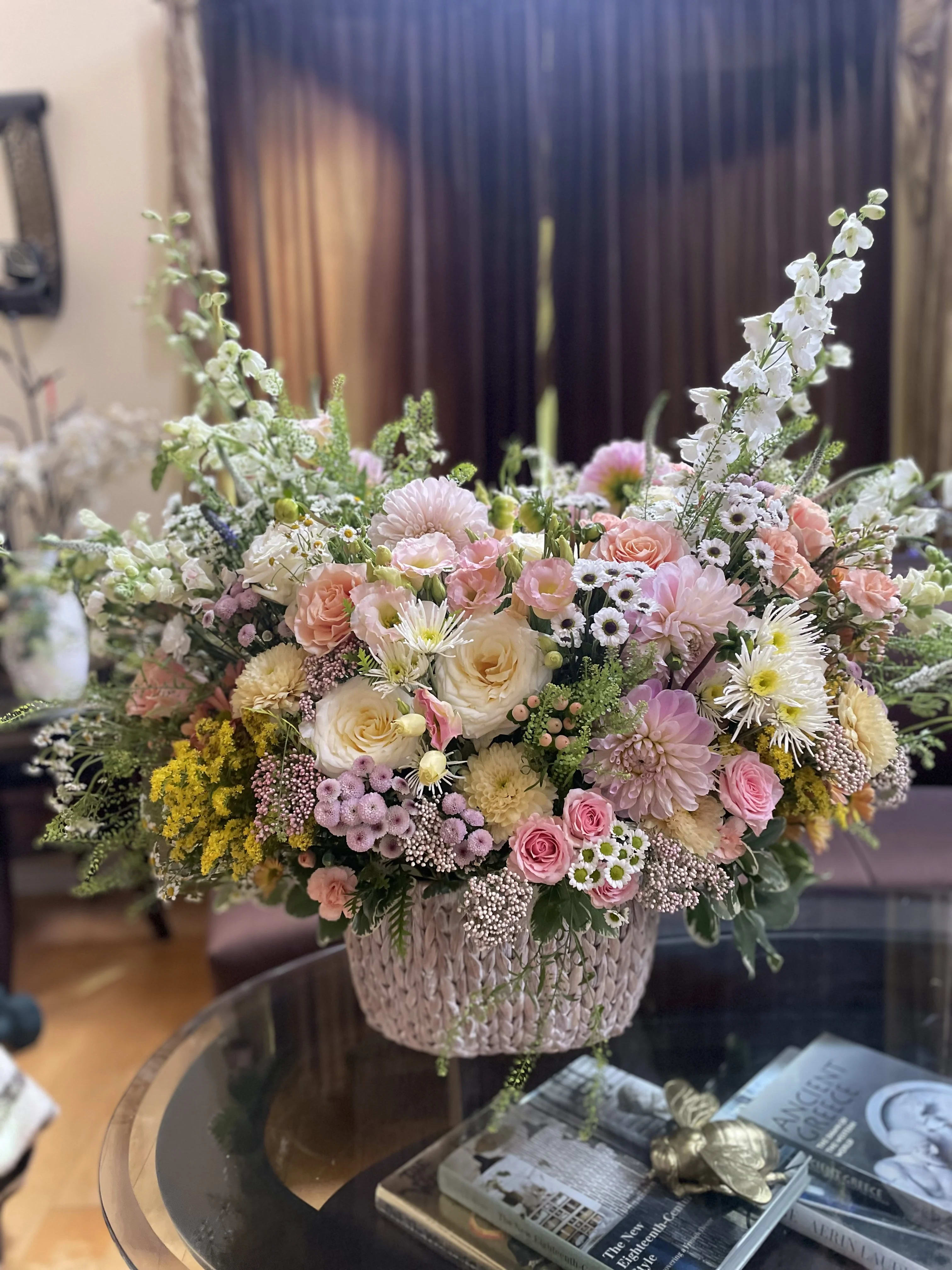 Large pastel flower arrangement in a woven basket