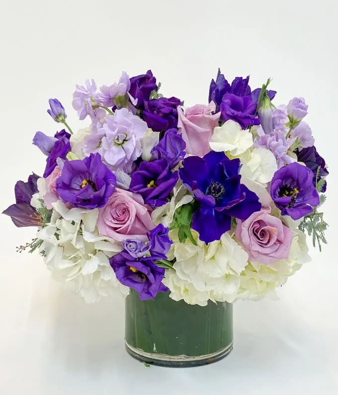 Purple and white bouquet in a glass vase