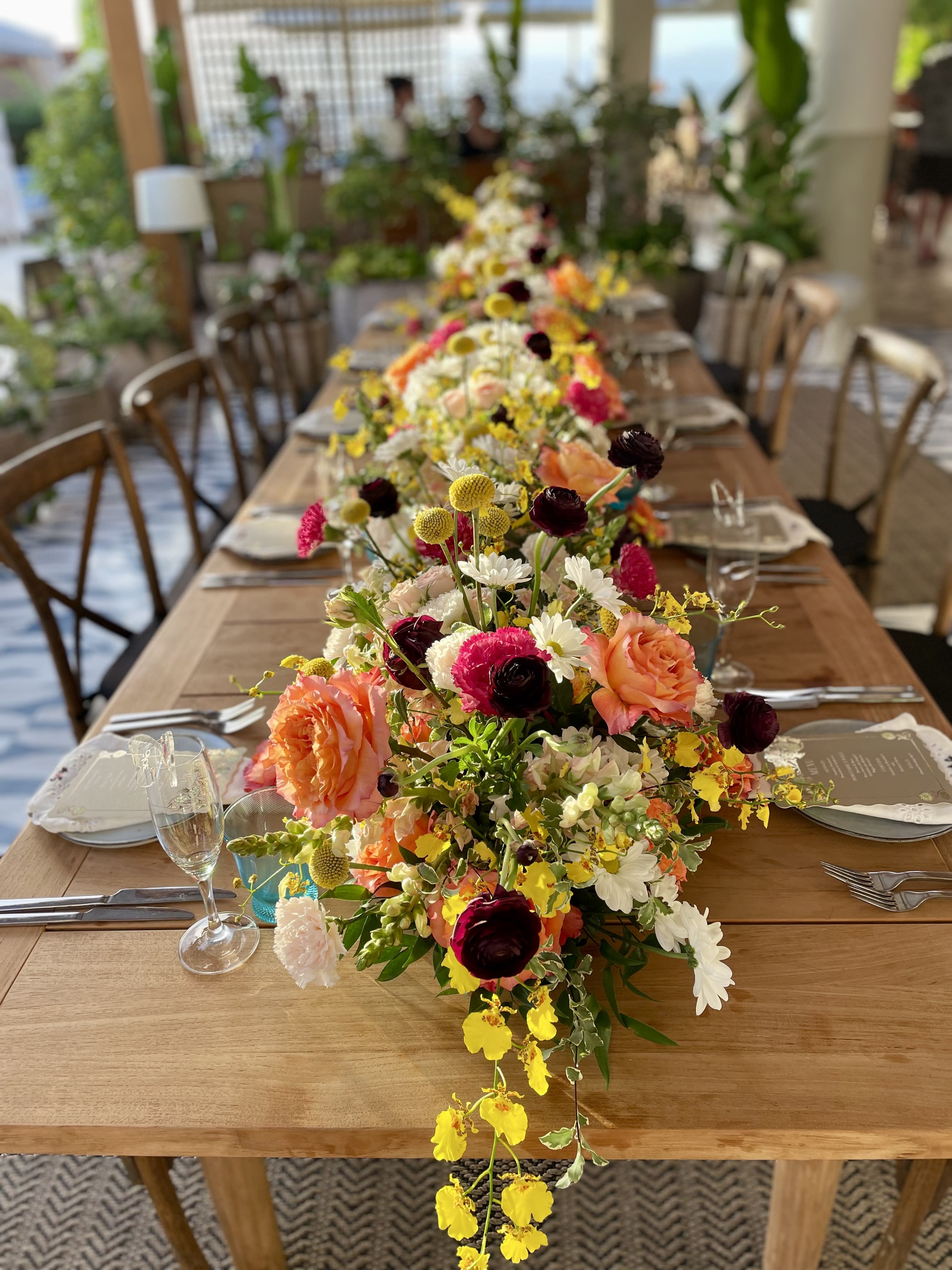 Long table with colorful floral centerpieces and place settings