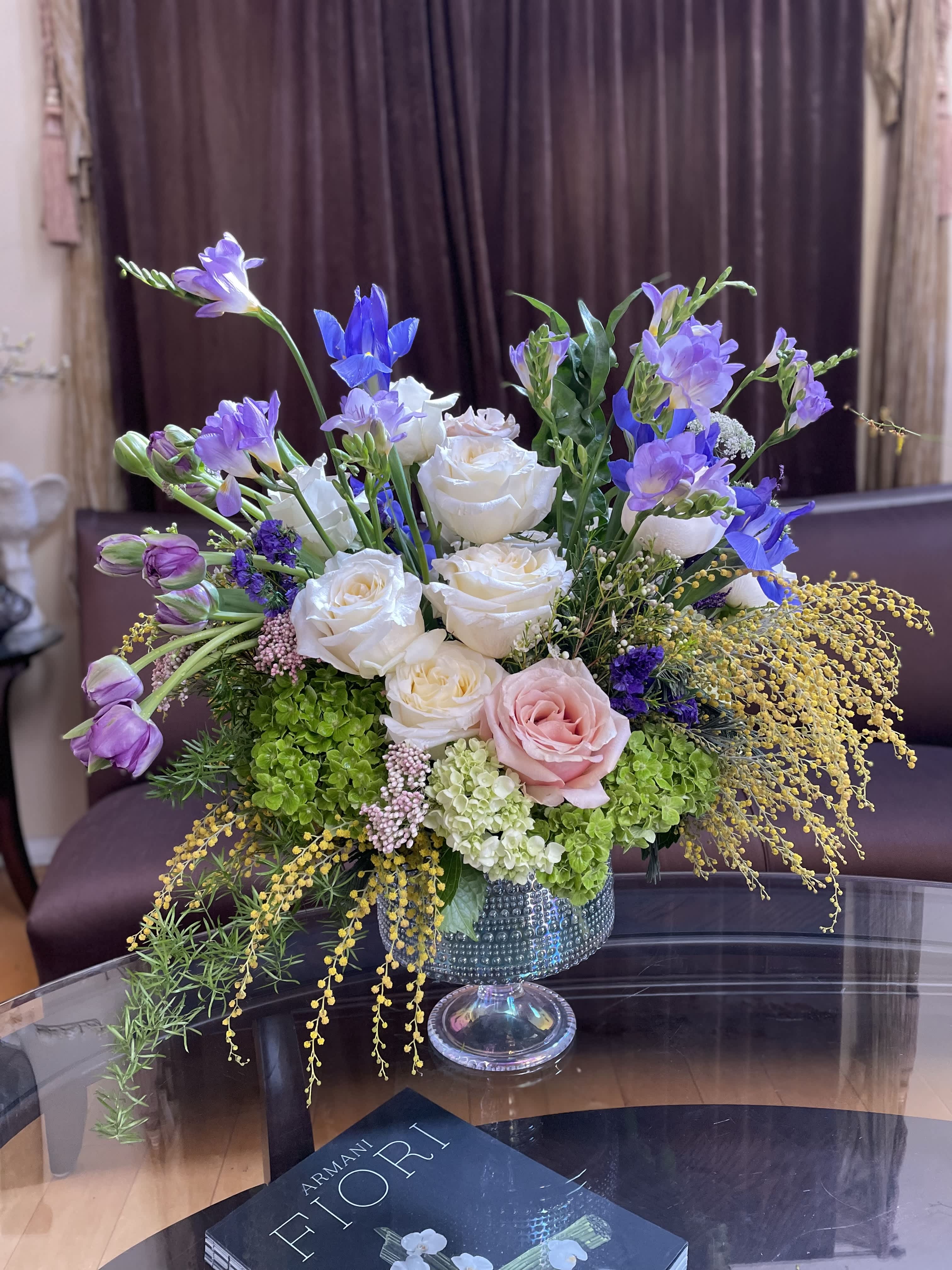 Mixed bouquet of white and pink roses with purple blooms in a glass vase