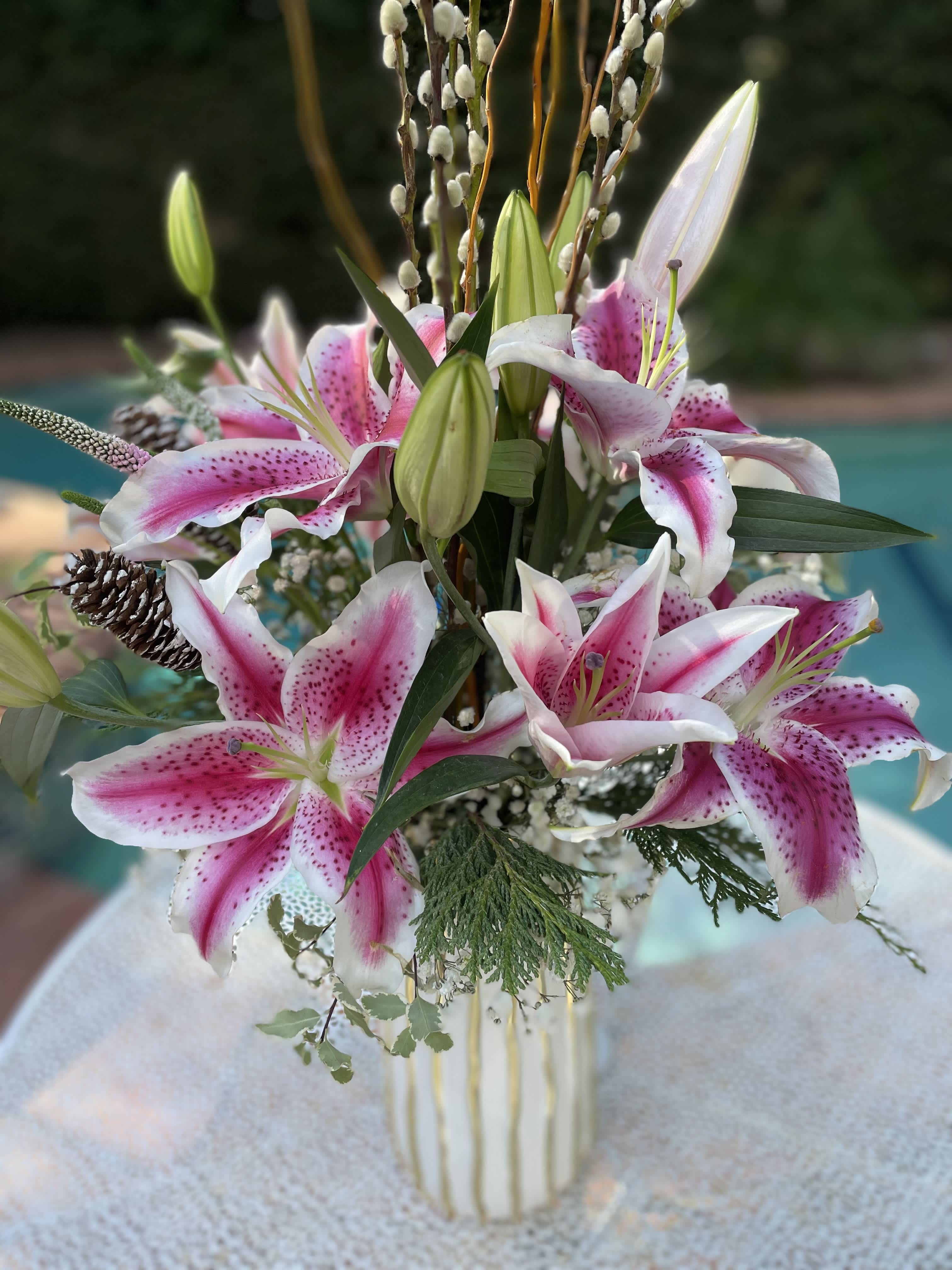Pink and white lilies arranged in a striped vase