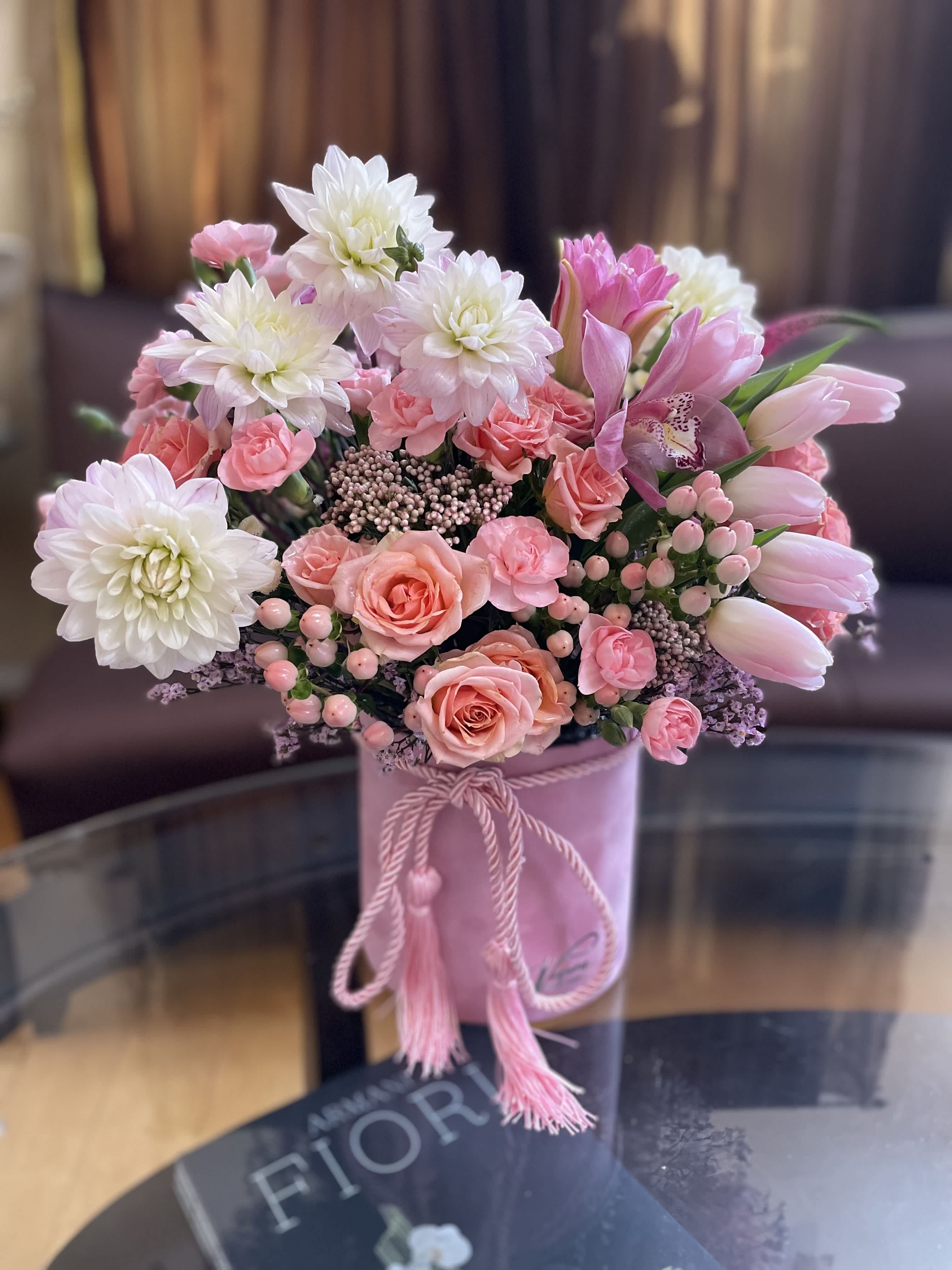 Pink and white bouquet in a pink hatbox with tassel cord
