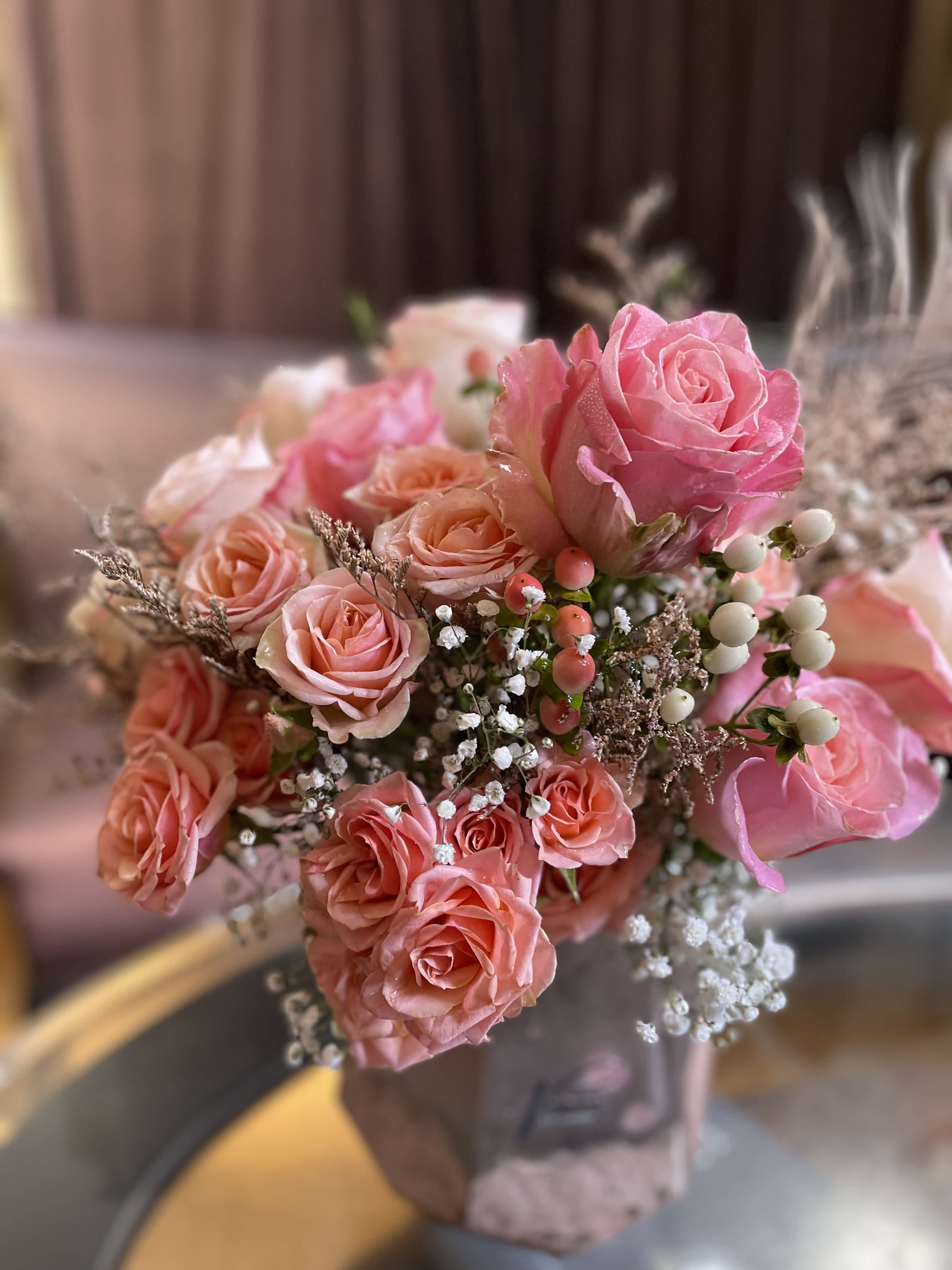 Pink and peach rose bouquet with baby's breath and berry accents