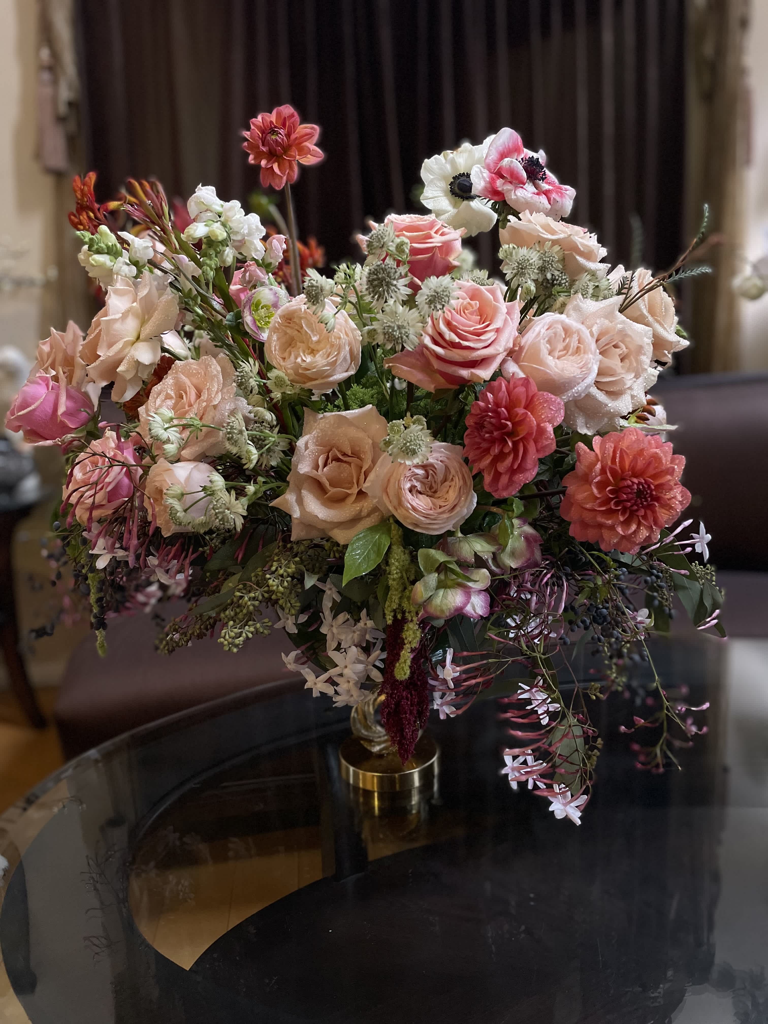Mixed pink and peach floral arrangement in a gold vase