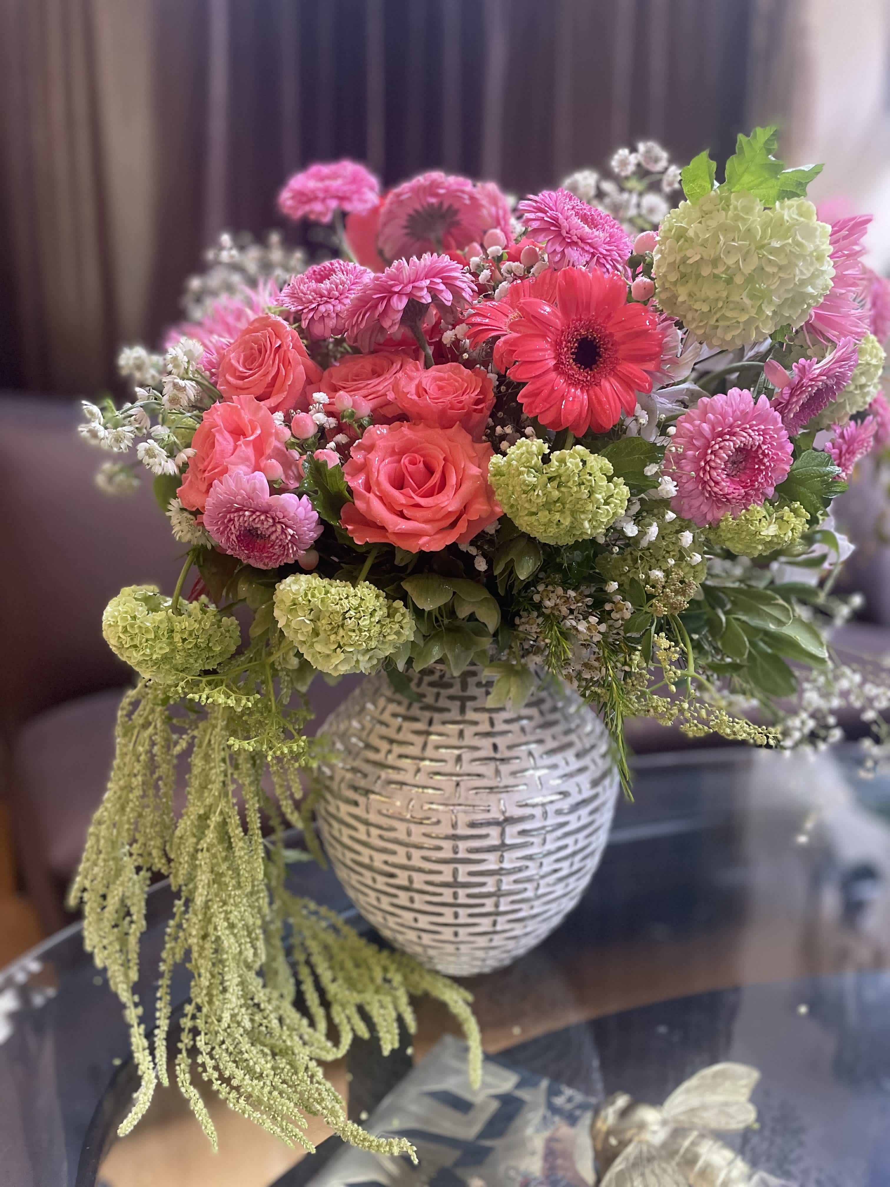 Pink and coral mixed bouquet in a white textured vase
