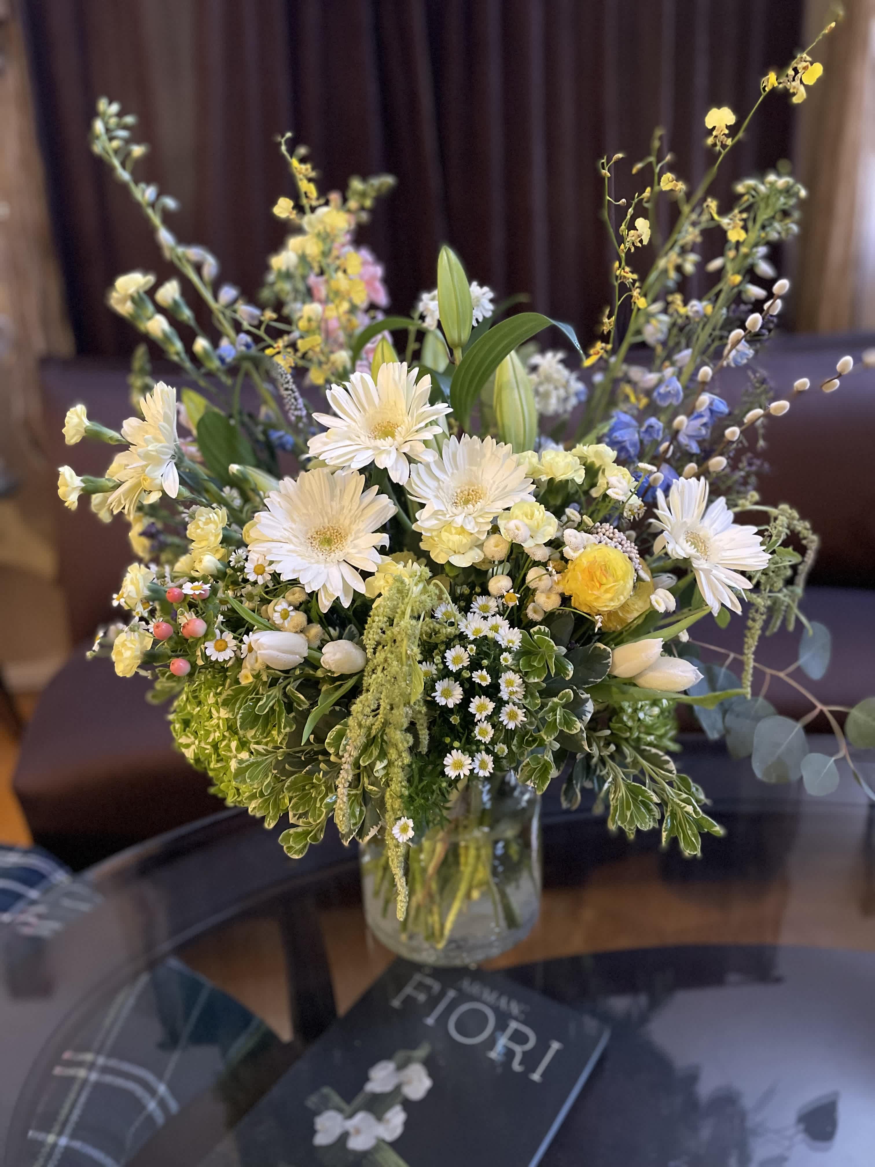 Mixed bouquet of white and yellow flowers in a glass vase
