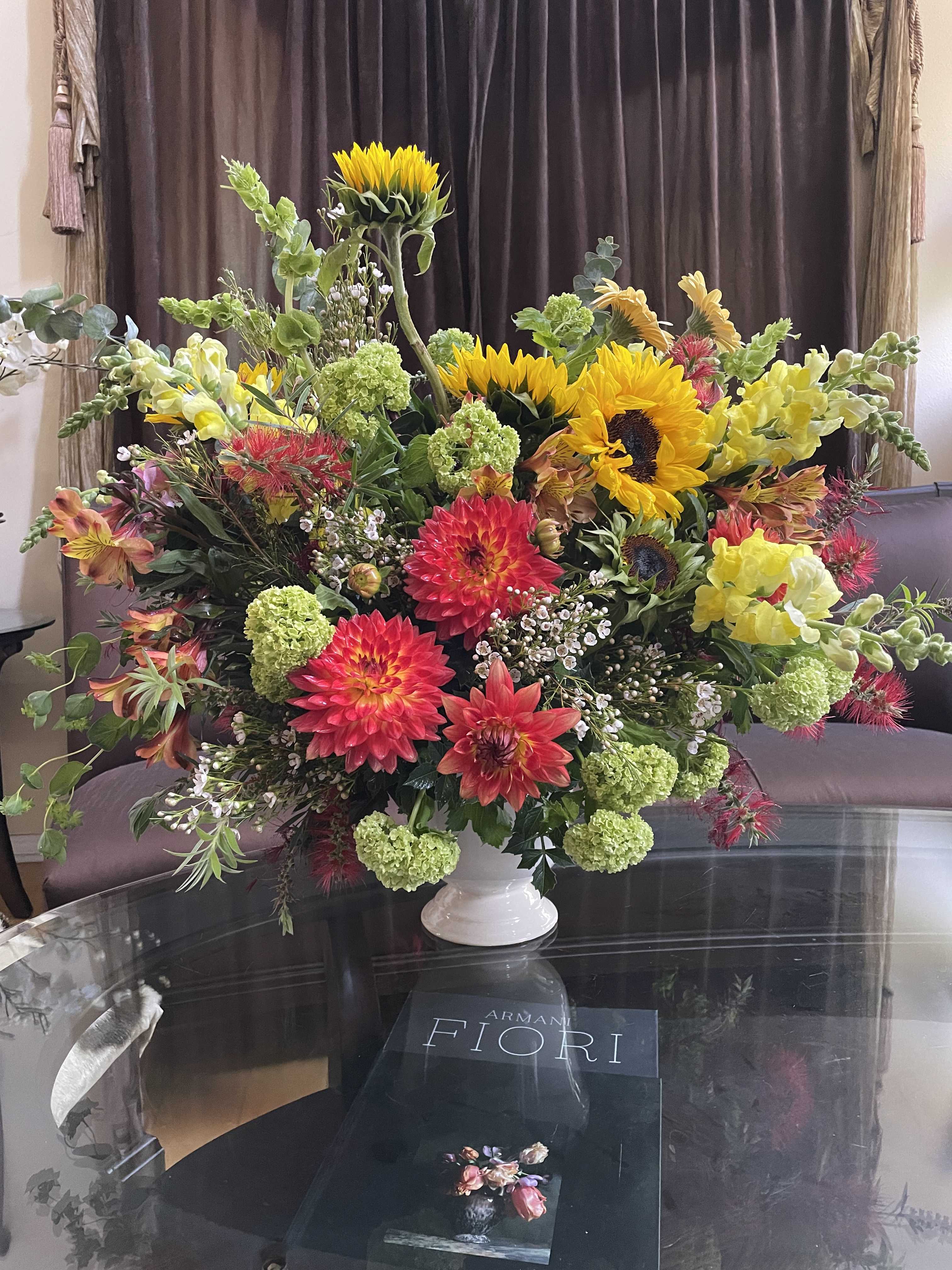 Large mixed bouquet with sunflowers, dahlias, and snapdragons in a white vase