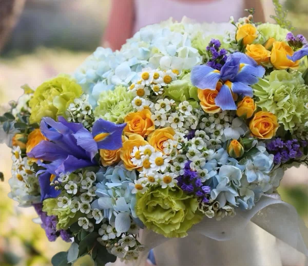 Colorful bouquet with blue hydrangeas, yellow roses, and purple irises