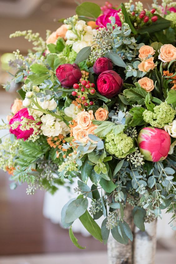 Bouquet of pink and peach flowers with mixed greenery